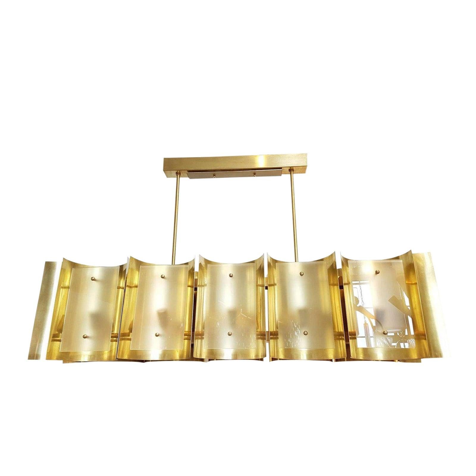 A D'lightus Mid-Century Modern style creation, custom made in limited editions.
As shown, the large rectangular shape chandelier, is made of 12 brass sheets, curved, nesting the light and covered up by a frosted glass, 
With 12 candelabra base