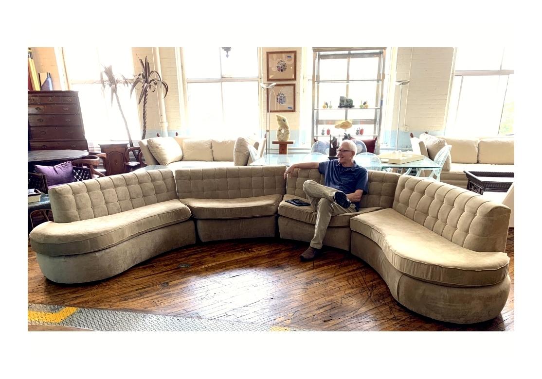 A Mid Century Modern style four piece sectional sofa with 2 contoured end units and 2 curved center units that offers ample seating. The sectional with button tufted backs, foam filled loose seat cushions and the whole resting on short black