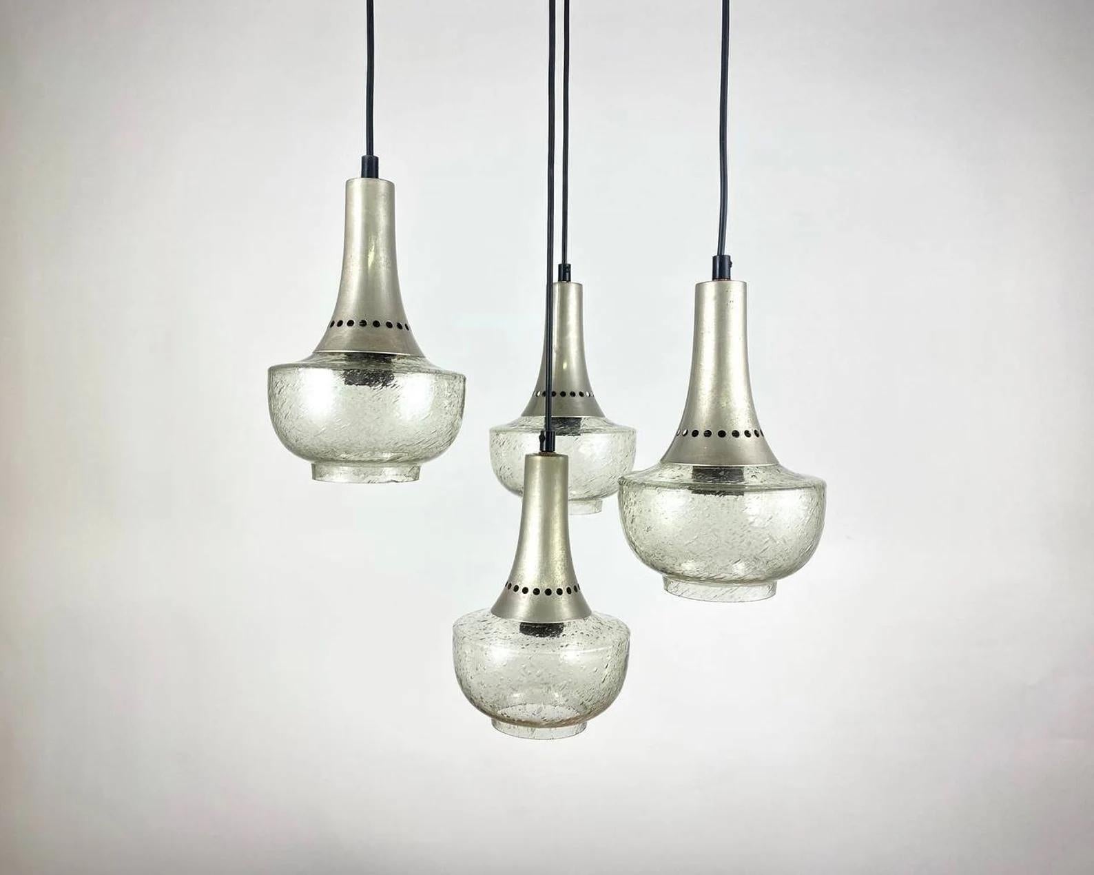 Vintage cascade chandelier/ 4-light pendant lamp in Mid-Century Modern style.

1970's Pendant Lighting with 4 glass shades mounted on a stainless steel structure.

Shades of glass will practically not prevent the passage of light. 

Tall