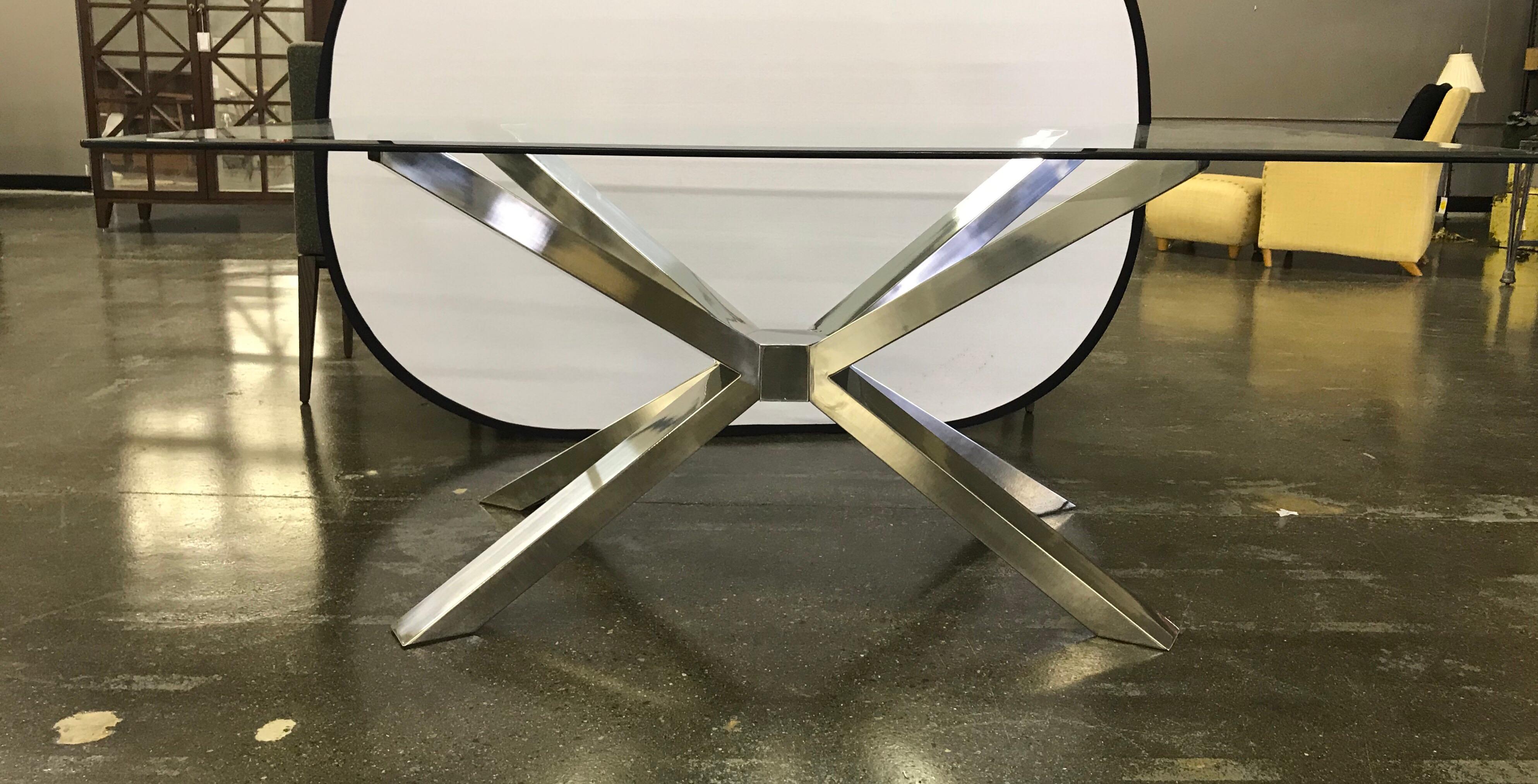 Sleek and sophisticated glass top dining table has a silver chrome sculptural base. 
The condition is mint and the base has spectacular architectural lines.