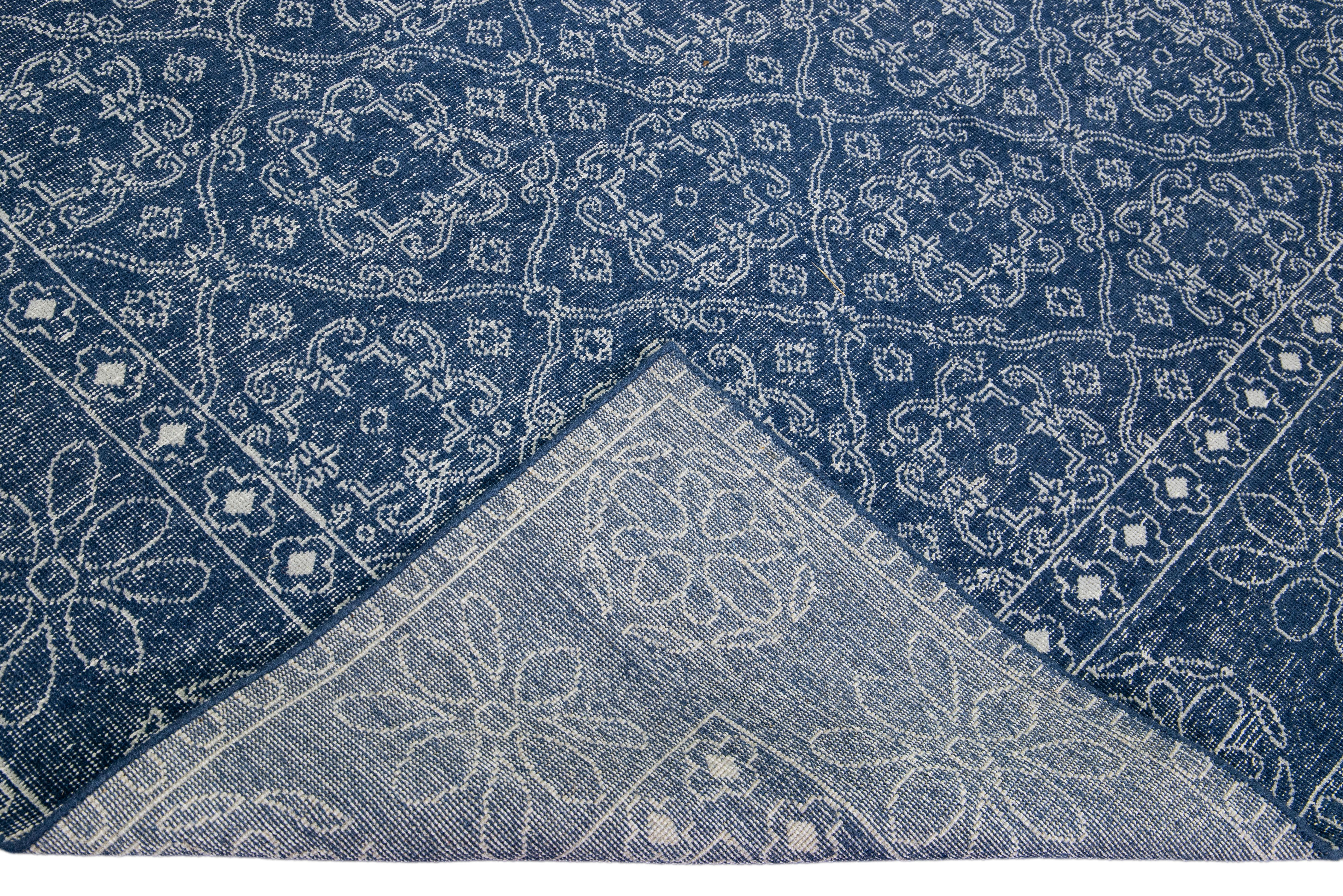Beautiful Turkish handmade wool rug with a blue distress look field. This Modern rug has white accents featuring a gorgeous all-over floral trellis design.

This rug measures: 9' x 12'1