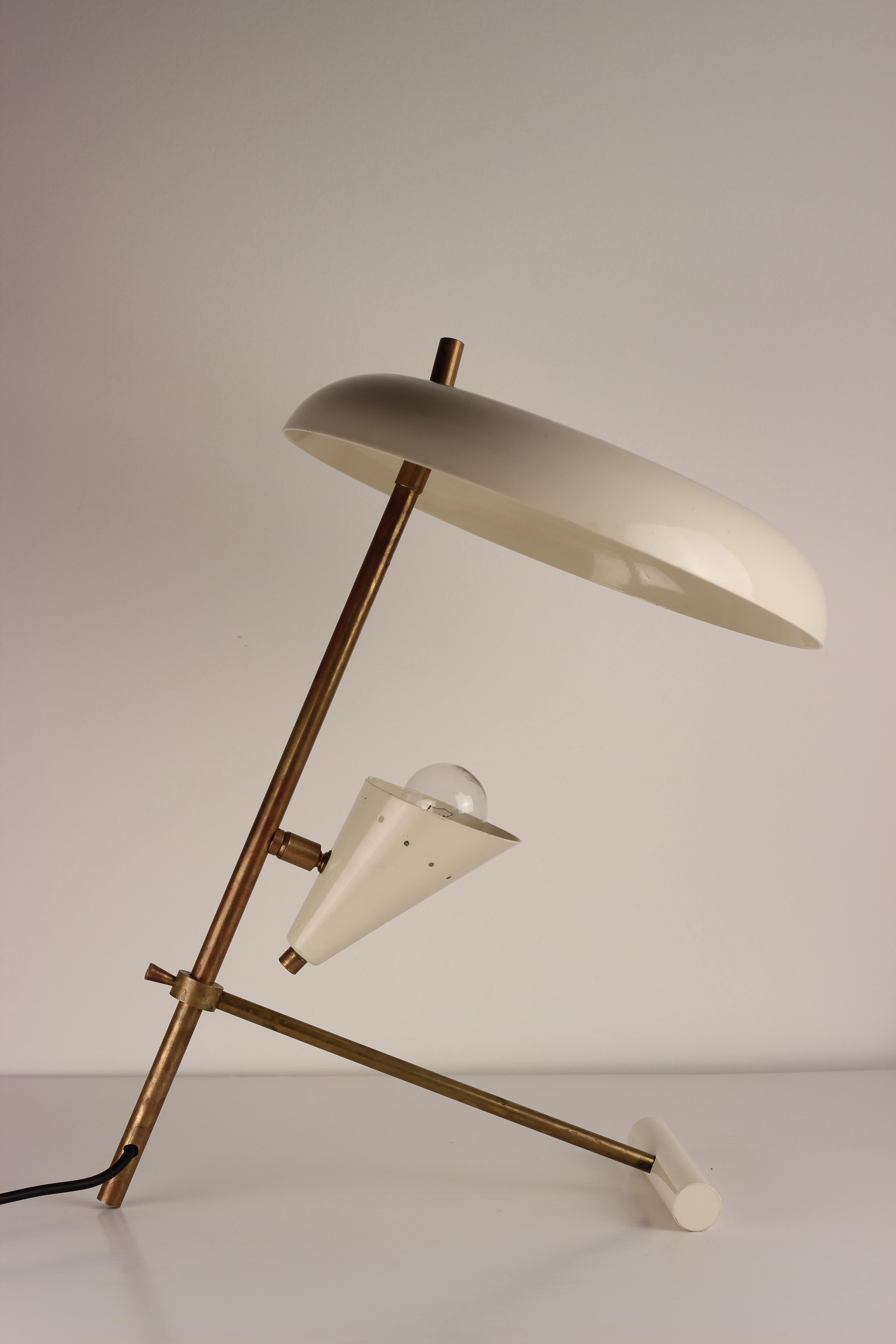 A Mid-Century Modern style Italian table lamp or desk lamp made of brass and white lacquered metal, with two directional designed lampshades, with one bulb holder in the smaller shade. We believe this piece to be of recent 21st century production