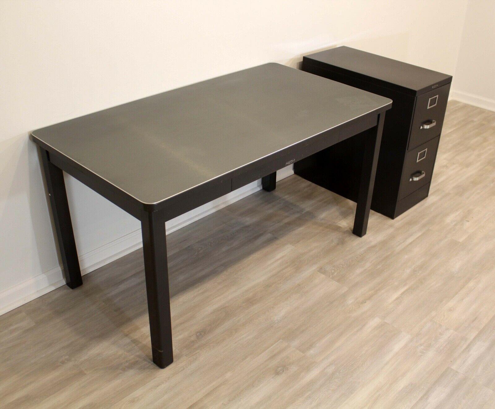 This Mid-Century Modern style desk and matching file cabinet was manufactured by the American company, McDowell & Craig. Built to last, this steel-welded frame and is finished with their pewter finish contrasted with a brushed stainless steel top.