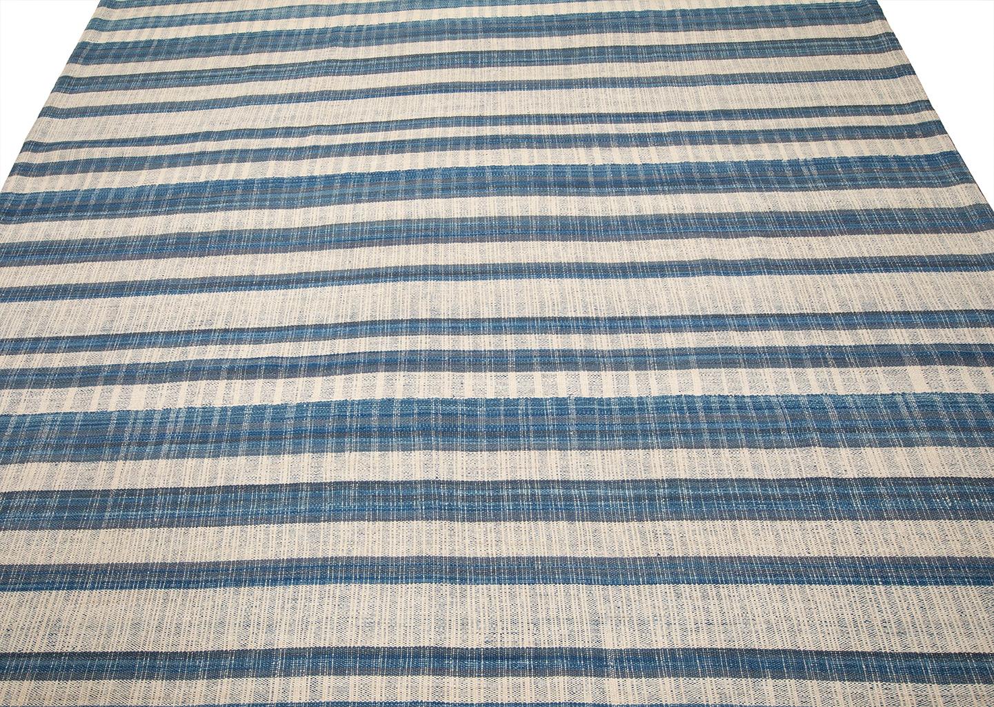 Questo tappeto Pelas a trama piatta è realizzato con 100% lana filata a mano e tinture naturali. Si ispira agli antichi kilim originari della regione curda dell'Iran. Nasiri continua la sua ricca tradizione nella produzione di tappeti applicando le