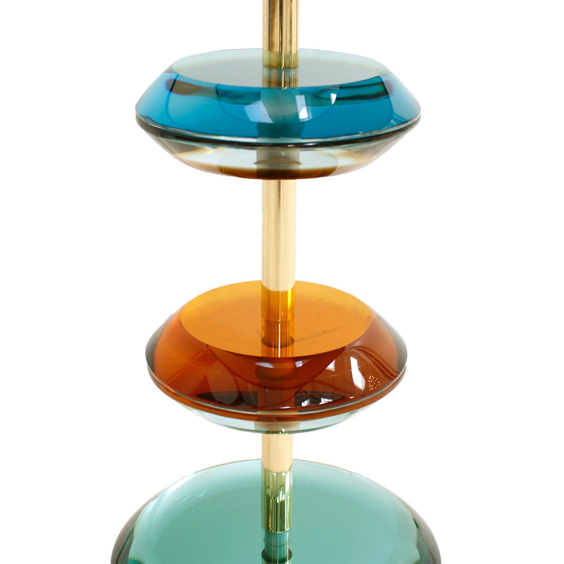 Pair of Table lamp designed by L.A. Studio, a true embodiment of elegance and craftsmanship. This exquisite lamp features a solid brass structure meticulously crafted to perfection, complemented by Murano colored glass pieces that add a touch of