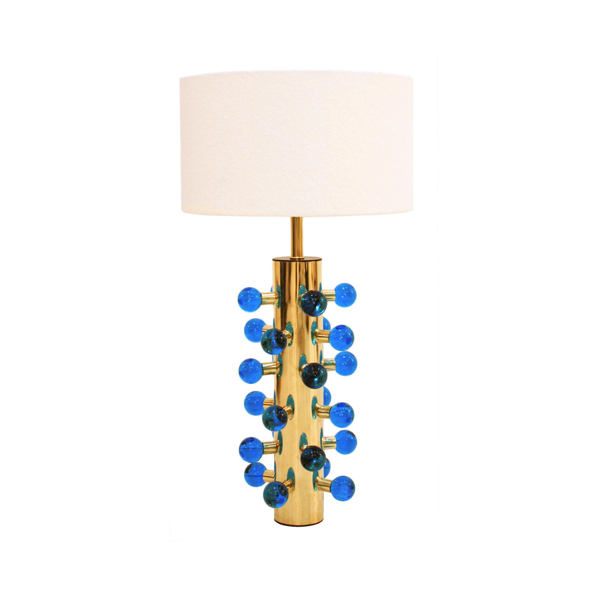 Contemporary maximalist pair of brass table lamps, a stunning blend of modern design and opulence. This exquisite lamp features a cylindrical Polished brass structure adorned with spherical Murano colored in blue glass pieces, adding a touch of