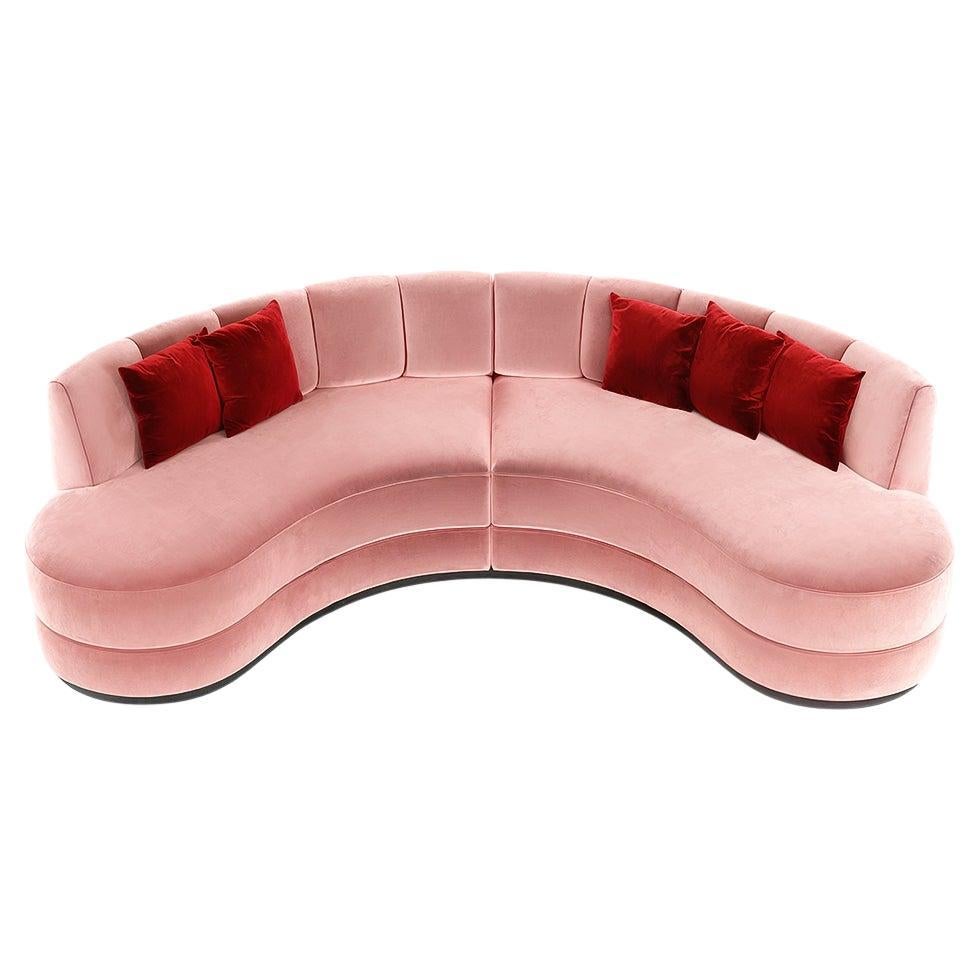 Este sofá curvado, una interpretación escultural de la elegancia moderna de mediados de siglo, está tapizado en terciopelo rosa que añade profundidad y estilo a cualquier ambiente. La silueta entallada presenta detalles de canales verticales a lo