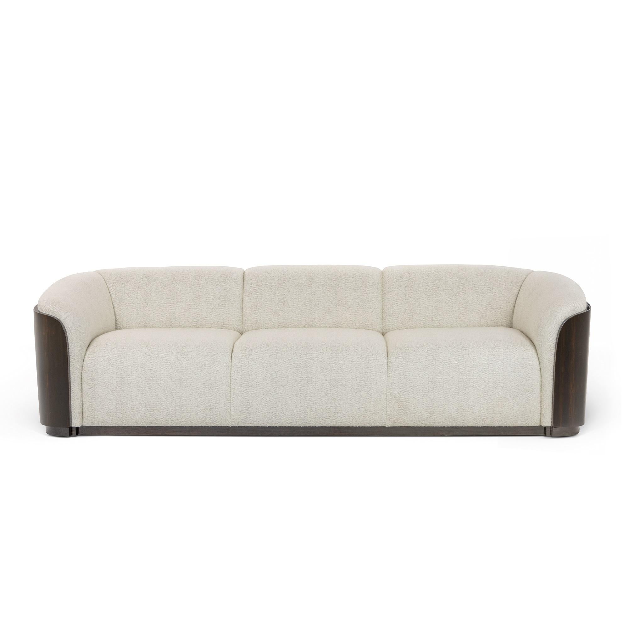Questo divano di lusso e di grande impatto è una splendida miscela di comfort e design. È dotato di un sedile imbottito per un comfort superiore. Il divano è definito da una struttura continua e avvolgente dello schienale e dei braccioli, che crea