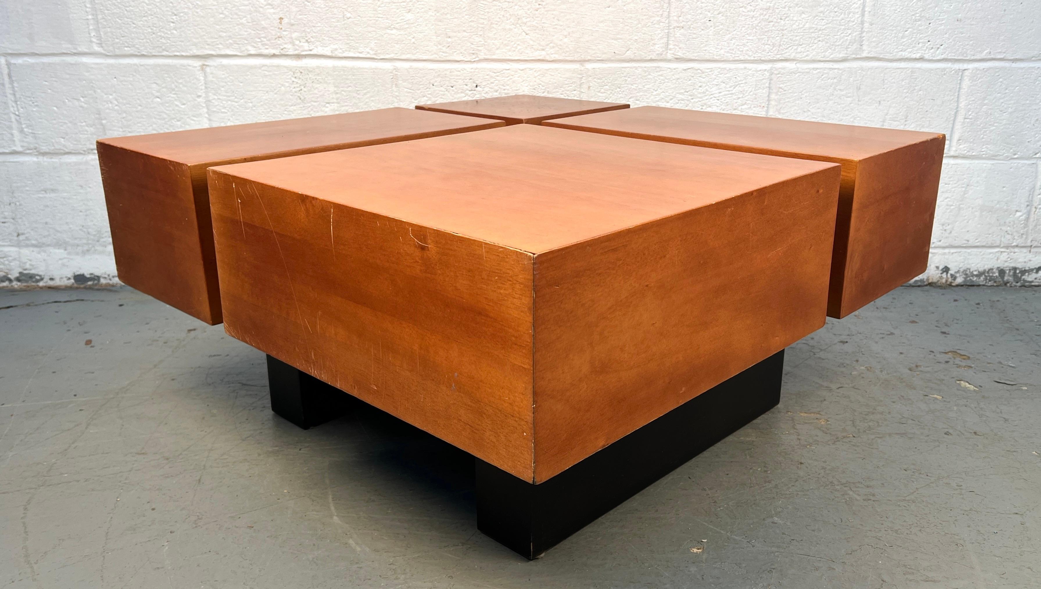 Un tavolino quadrato in legno in stile metà secolo moderno, caratterizzato da linee pulite e da una calda finitura naturale. La sua silhouette semplice la rende versatile e facile da abbinare a un'ampia gamma di interni, mentre la struttura robusta