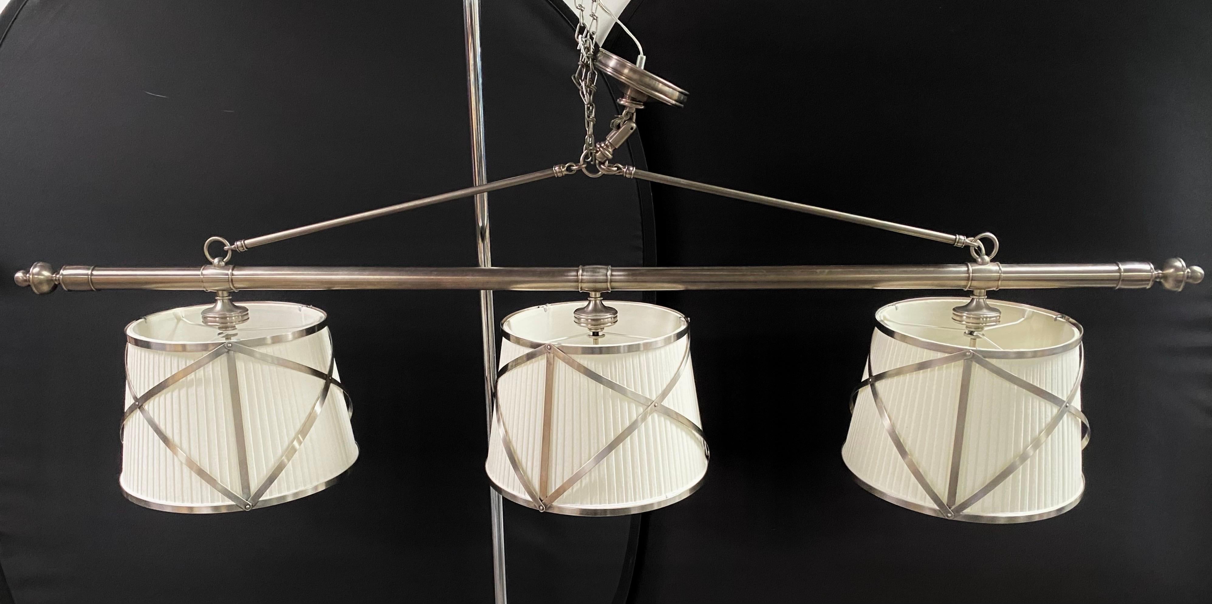 The Mid-Century Modern-style three-light pendant is a striking luminary crafted to grace your billiard room, kitchen, or dining table with both style and functionality. 
Its three luminous domed linen shades, gently diffusing the radiance within,