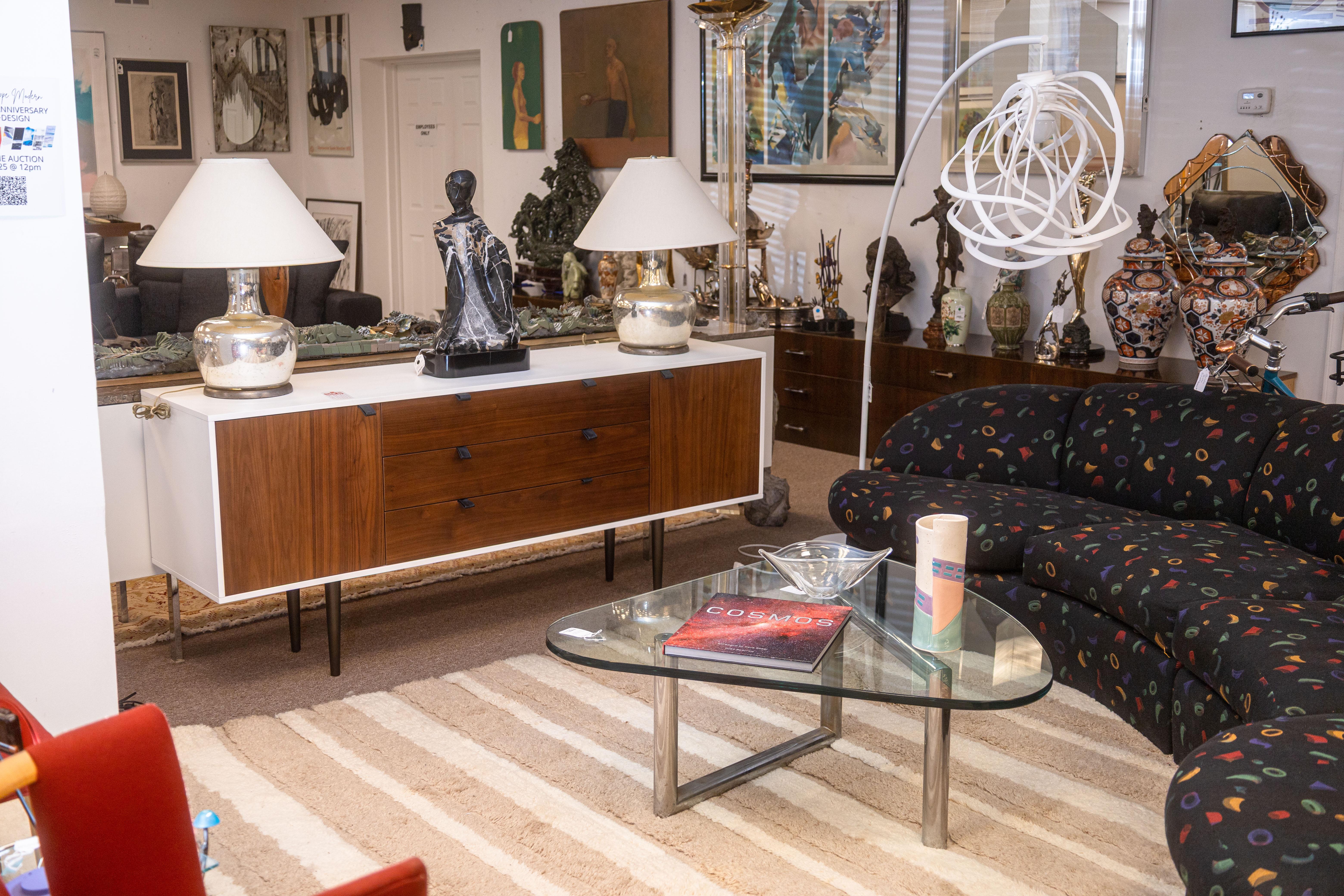 Mid century modern style chrome and glass coffee table. This lovely coffee table takes inspiration from the iconic designs of Isamu Noguchi, taking his free-form sculpted wood bases and converting them into a modern tubular chrome form. This table