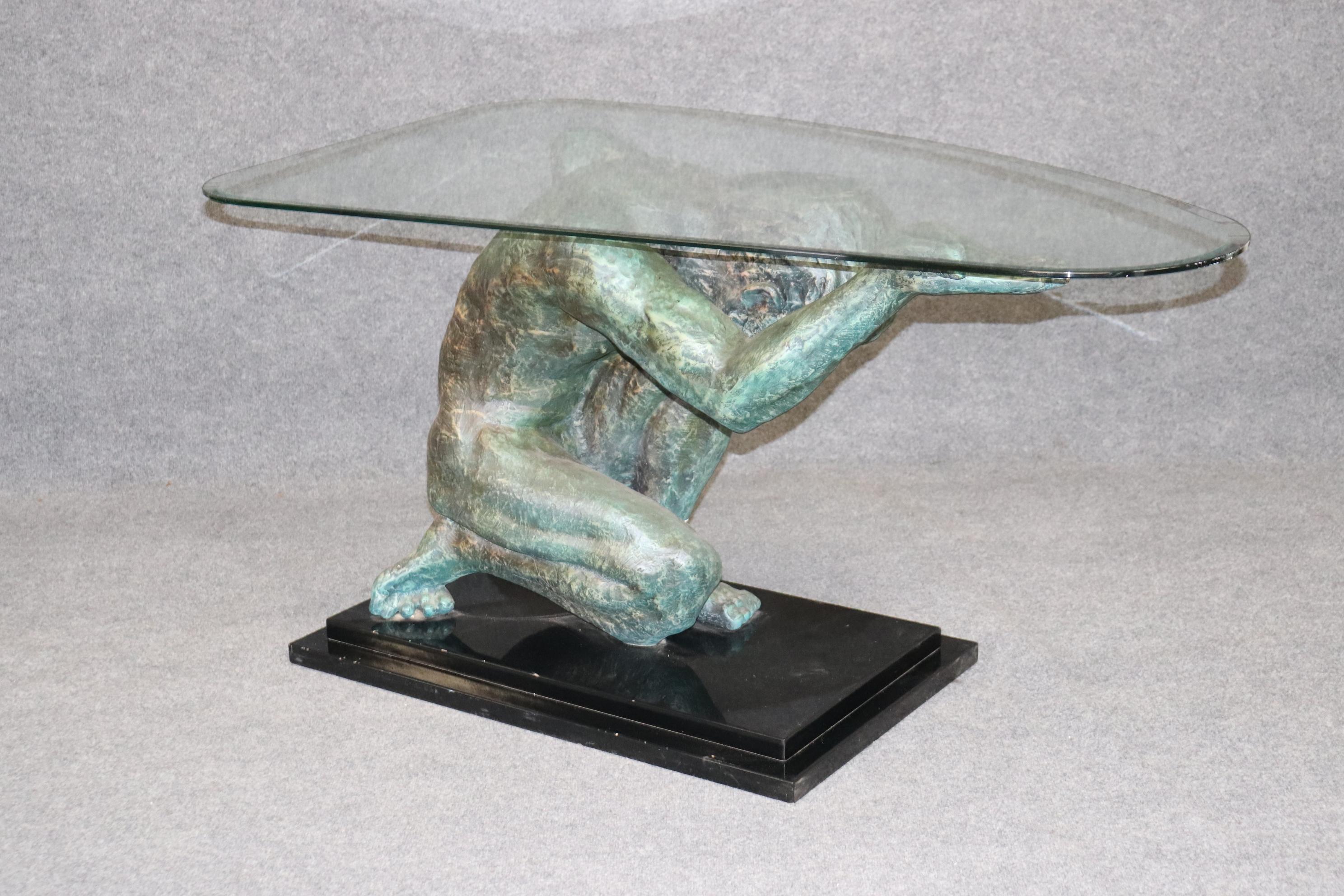 This is a gorgeous bronze-looking composite Auguste Rodin Style figure of Atlas holding up the weight of a thick piece of glass. The table top has a very small chip which if asked, we can have professionally polished away so it may not appear at