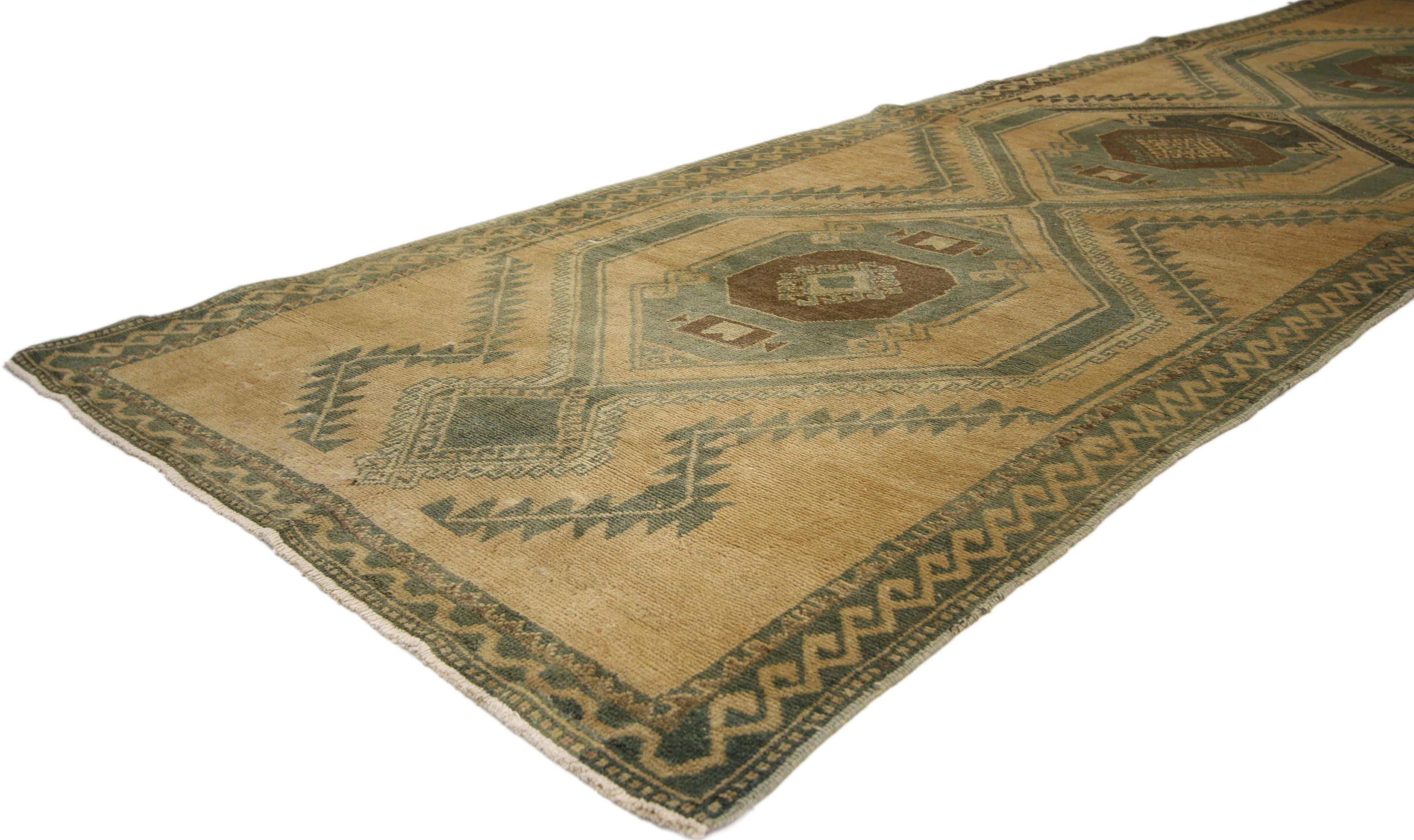 50351, Mid-Century Modern style vintage Turkish Oushak runner, hallway runner. Warm, rich and neutral, this hand-knotted wool vintage Turkish Oushak runner features three interconnected hexagonal medallions with diamond pendants across an abrashed