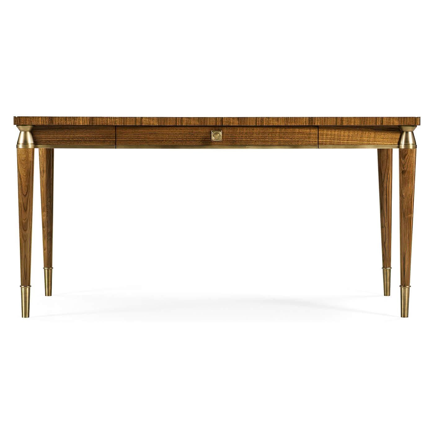 Mid-Century Modern style walnut desk with a quarter veneered writing surface, a long drawer, brass capital, and raised on turned and tapered legs with brass caps.

Dimensions: 60