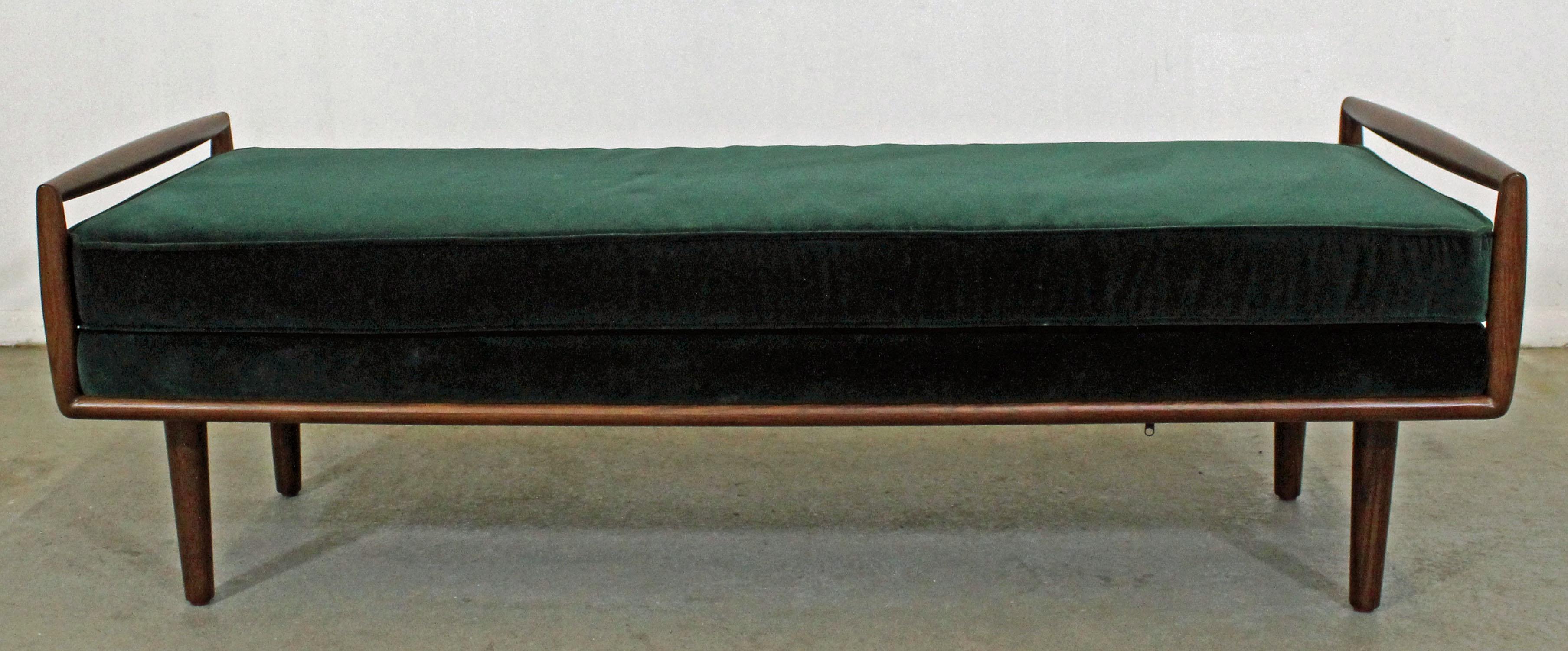 Offered is a beautiful Mid-Century Modern style window bench. This is a modern reproduction from the late 20th century, but still has a great look with a sculpted walnut base on pencil legs and clean velvet upholstery. It is in excellent condition