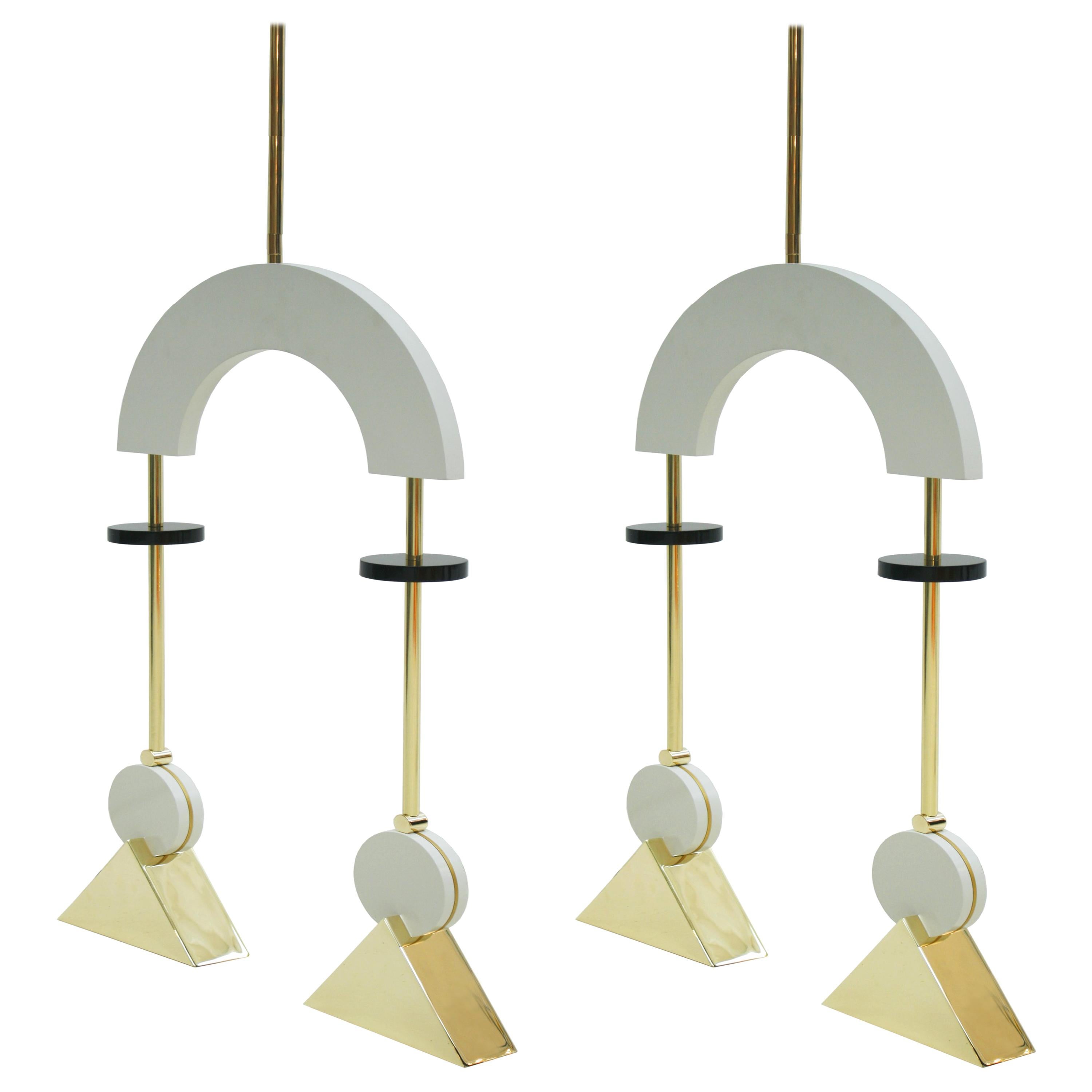 Pendant lamps composed of two points of light. Made of gold-plated bronze structure with white and black lacquered wood pieces. The design of this item was Inspired by the radical geometry of Constructivist art. The pendant lamp is constructed from