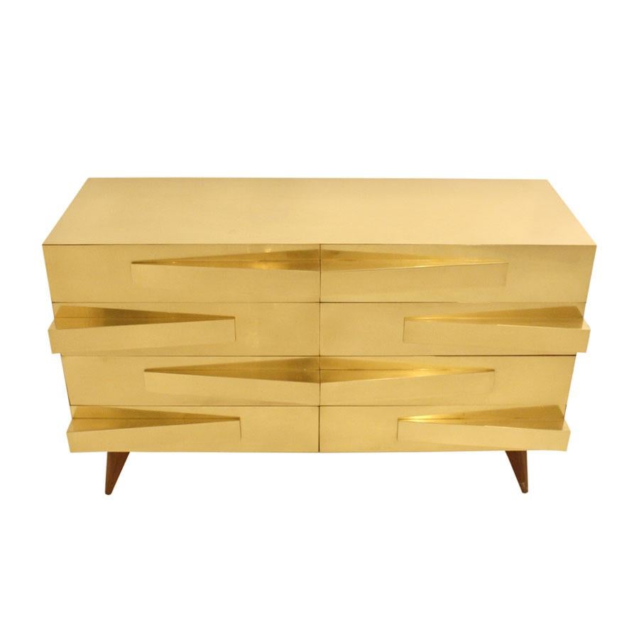 Questo comodino italiano in stile Mid-Century Modern presenta una struttura in legno massiccio degli anni '50, completata da accenti in ottone. Comprende otto cassetti con maniglie geometriche, che combinano la praticità dell'archiviazione con