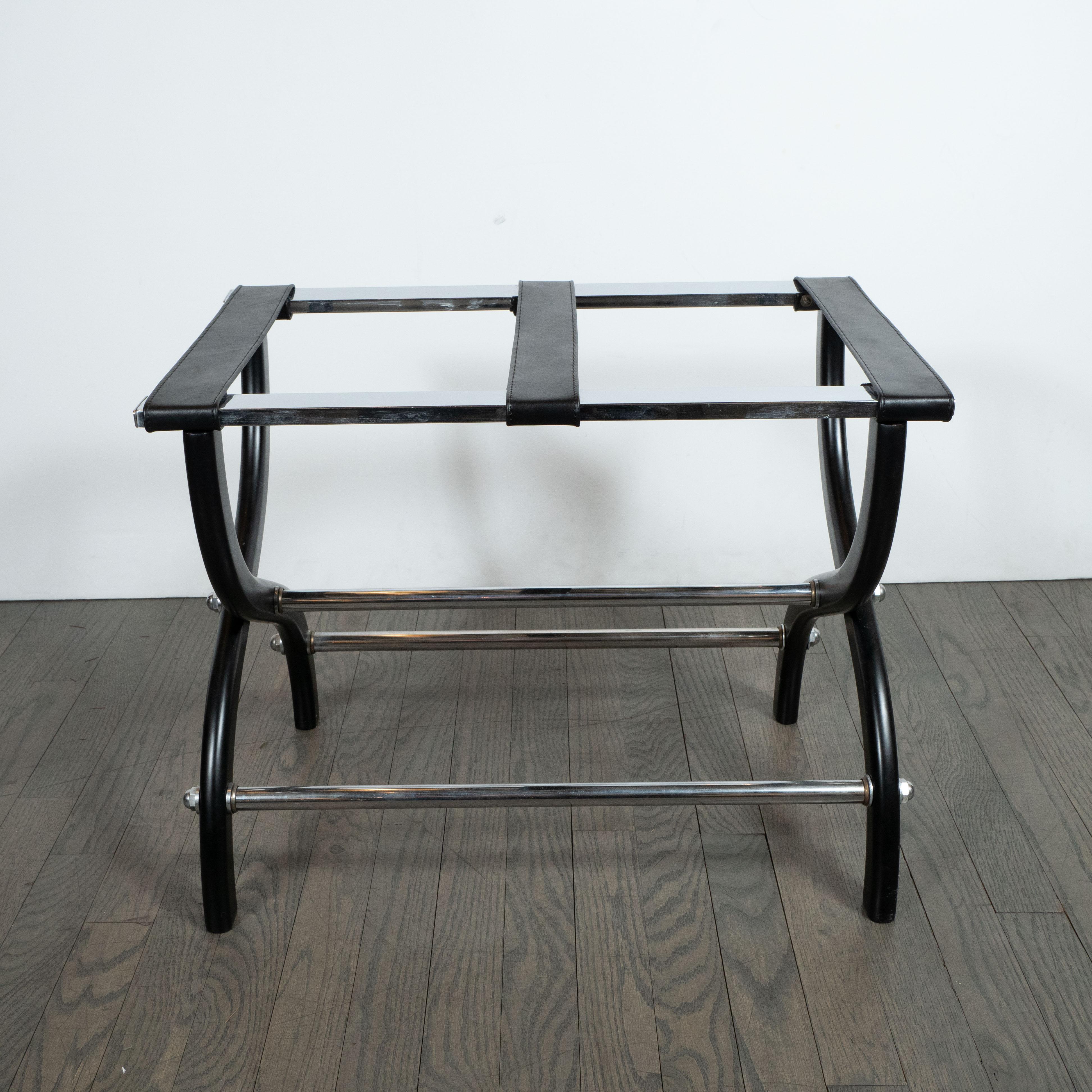 This handsome and stylish luggage rack was realized in the United States, circa 1960. It features curvilinear legs that meet in the center to create a stylized X-form base. The ebonized walnut legs are adjoined by cylindrical chrome supports that
