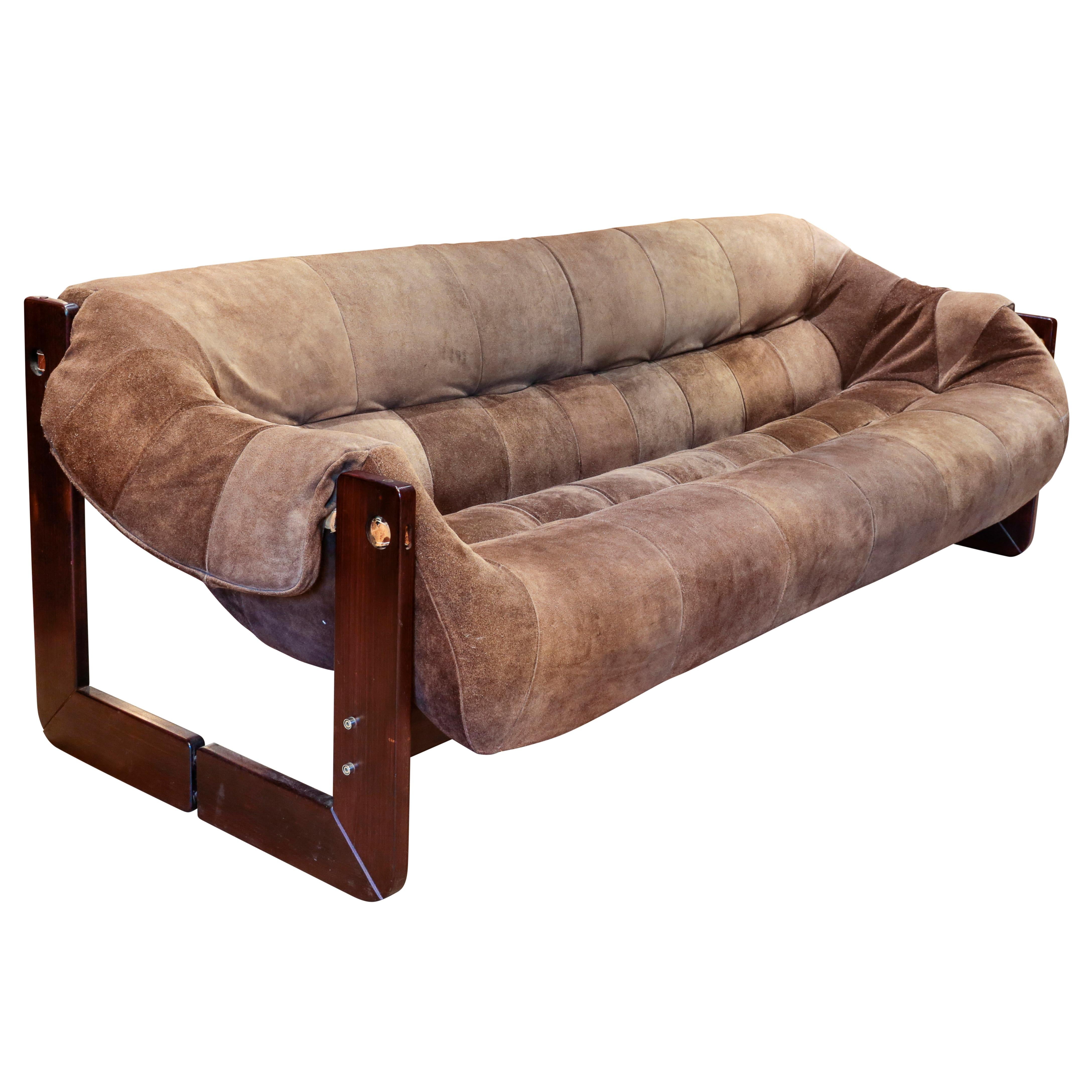 The frame crafted of heavy Brazilian rosewood solids, the sofa's pre-formed seat, back and arm cushions upholstered and hand-tufted in the original brown patchwork suede leather, Brazil, circa 1965.