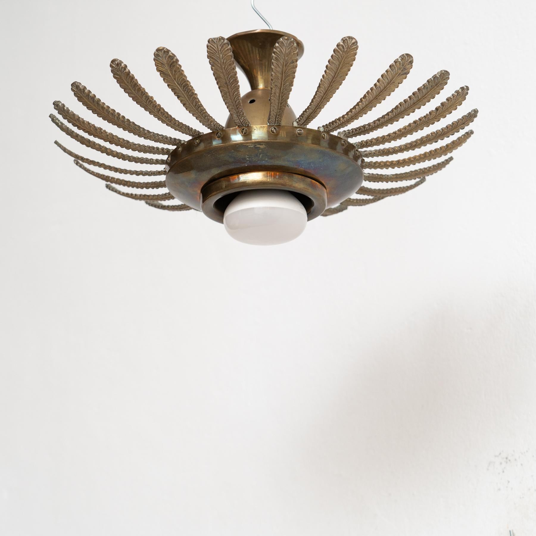 Fai un salto indietro nel tempo con il fascino di una lampada da parete in ottone a raggiera Mid-Century Modern, un gioiello di design del 1960 circa, immerso nelle tradizioni dell'artigianato francese. Realizzato con cura meticolosa e attenzione ai