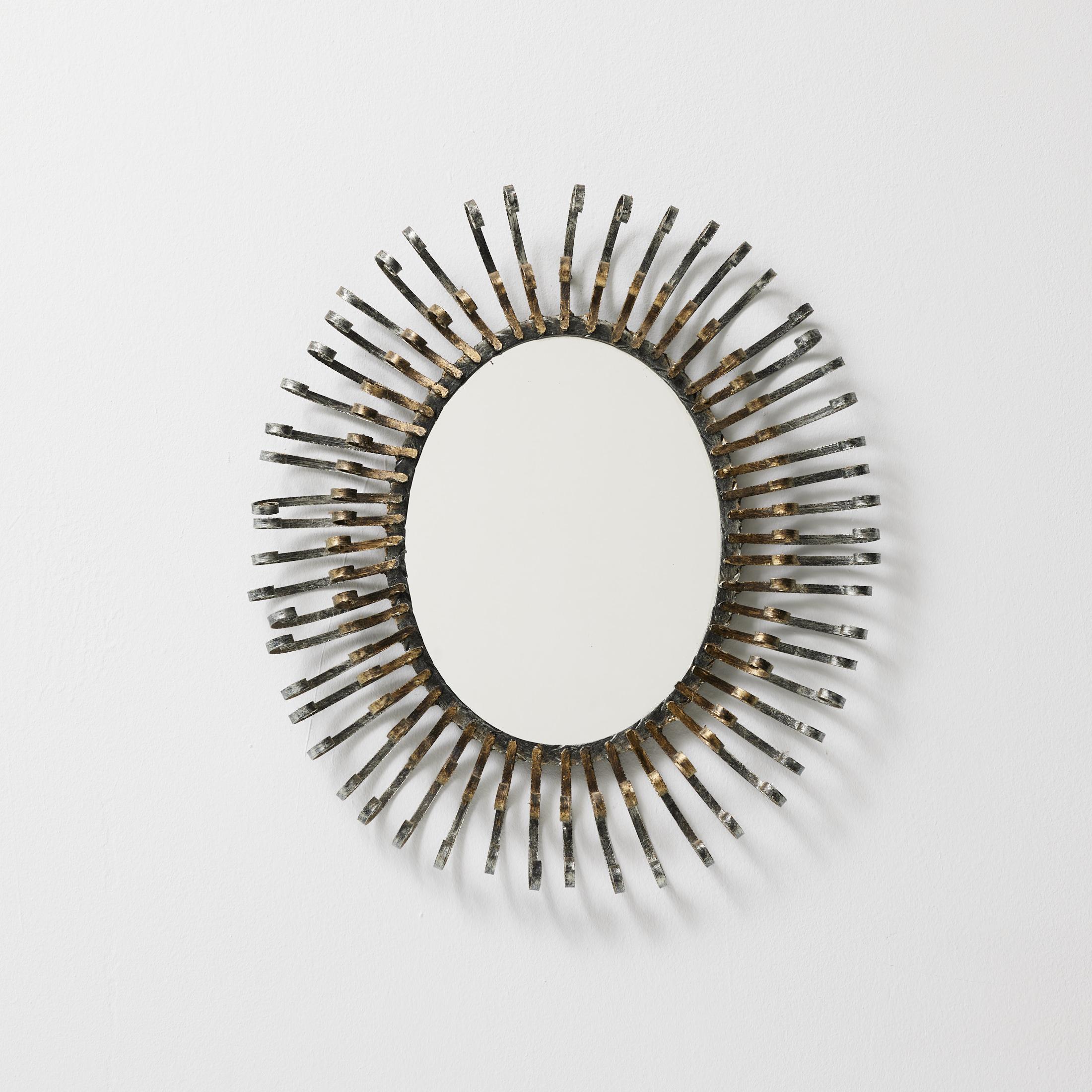 Brutalist Sunburst Mirror — France, 1970s
Hand-Forged Metal with Original Patina

This striking Brutalist sunburst mirror from 1970s France features bold, hand-forged metal rays radiating from an oval center. Echoing mid-century sunburst designs but