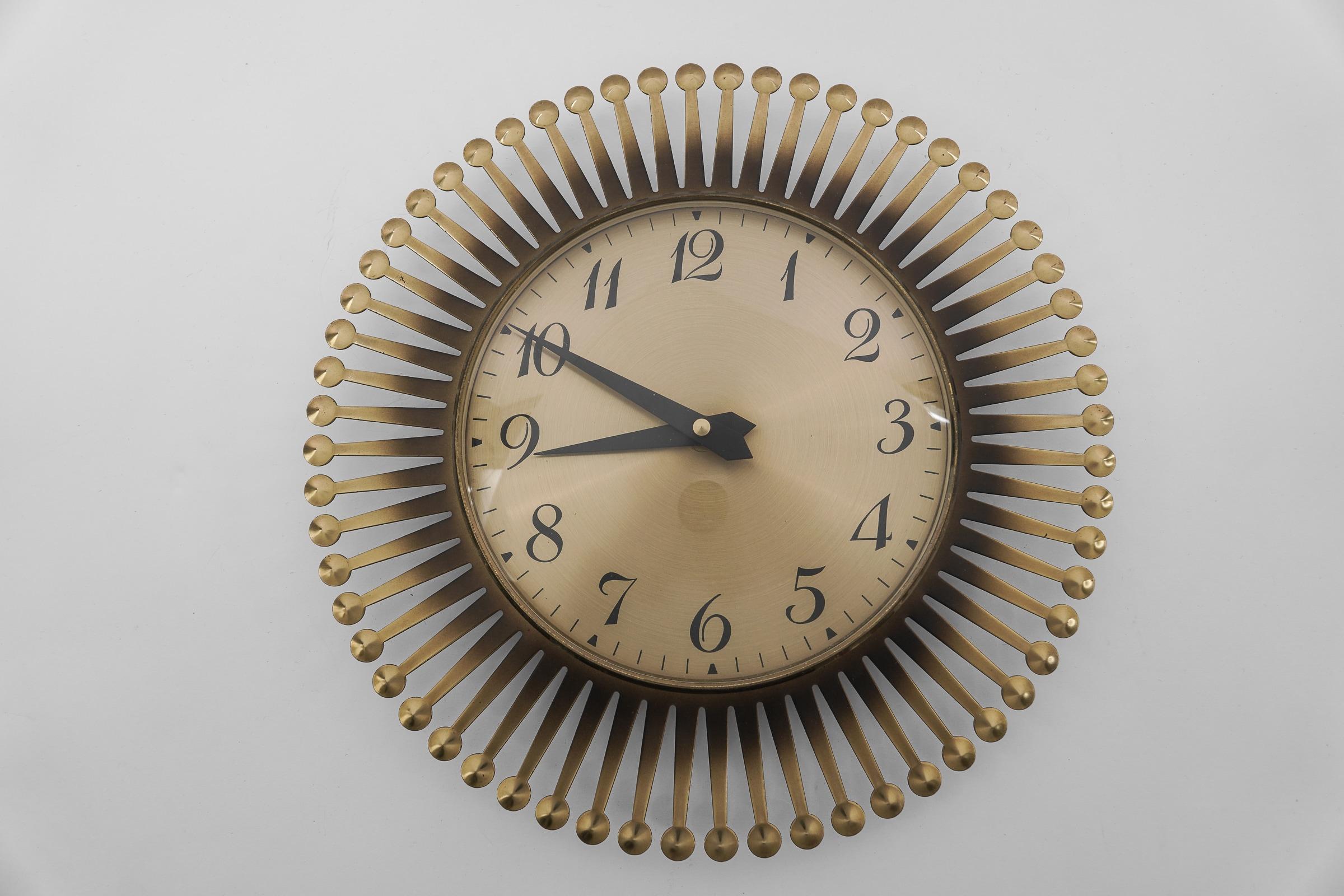 Stunning sunburst wall clock made of brass, metal and glass. 

One of the most beautiful models I have seen to date.

An eye catcher par excellence.

Made in Germany.

Electric, battery operated clock.