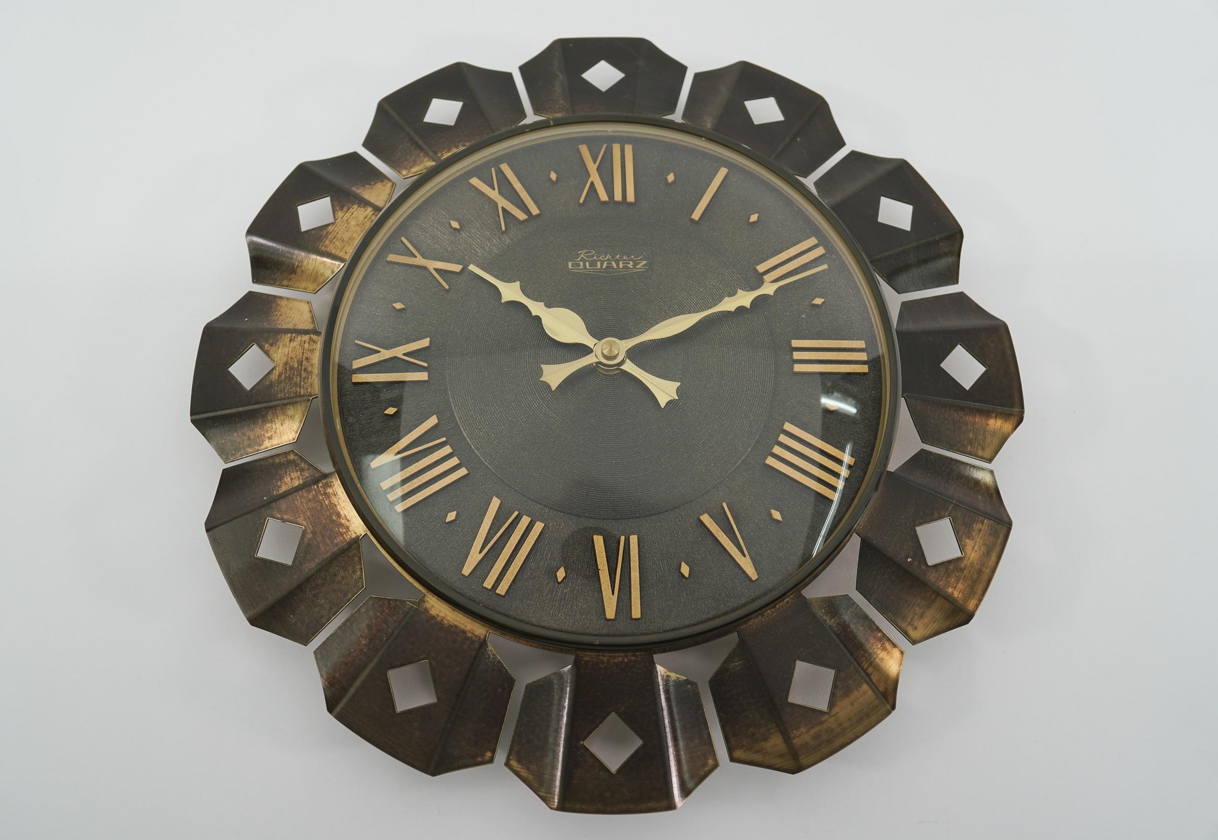 Stunning sunburst wall clock made of brass, metal and glass. 

One of the most beautiful models I have seen to date.

An eye catcher par excellence.

Made in Germany.

Electric, battery operated clock.