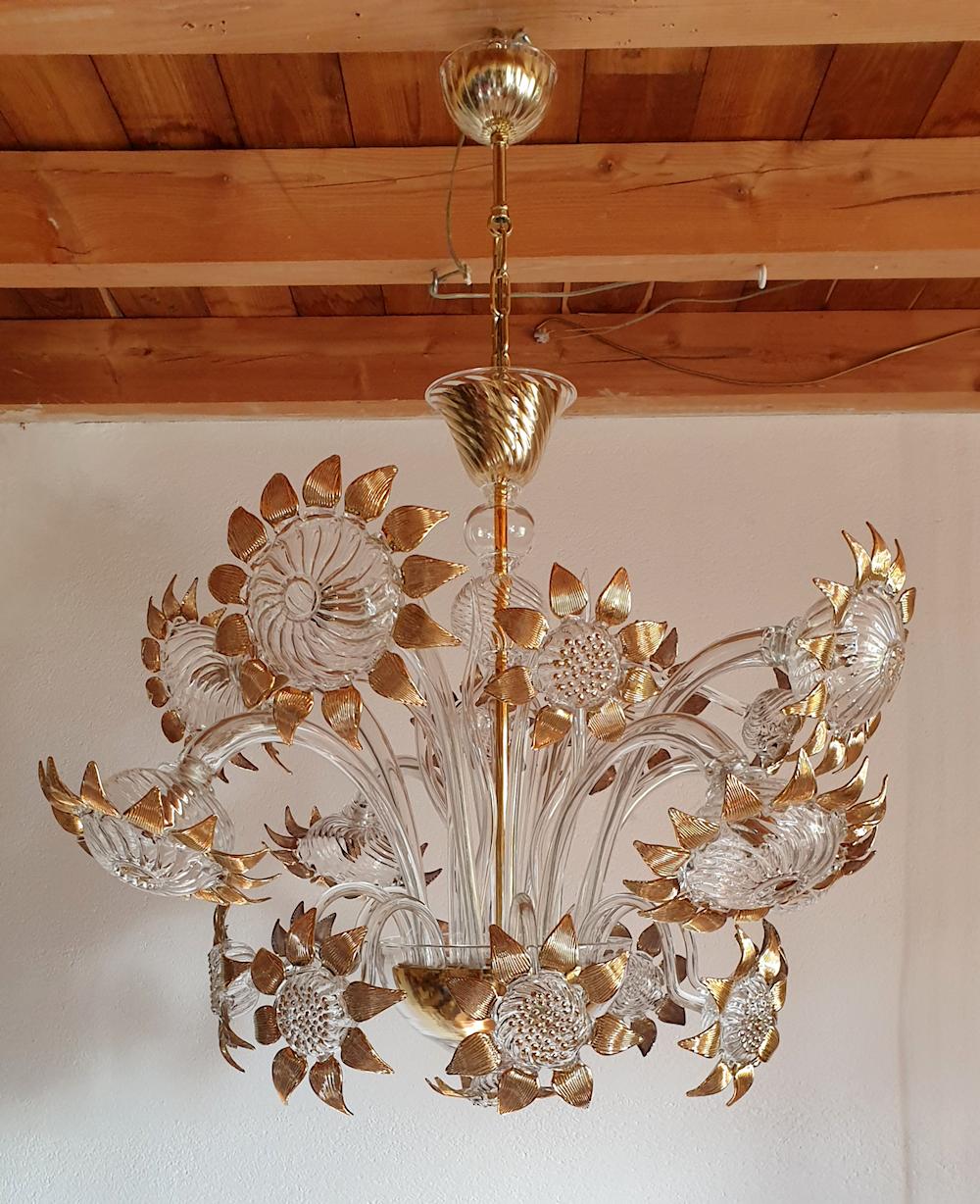 Large floral Mid-Century Modern eight lights Murano glass chandelier, attributed to Seguso, Italy, 1970s.
The vintage Murano chandelier has a sunflower decor, with the light bulbs nested inside the largest eight flowers.
It's made of clear Murano