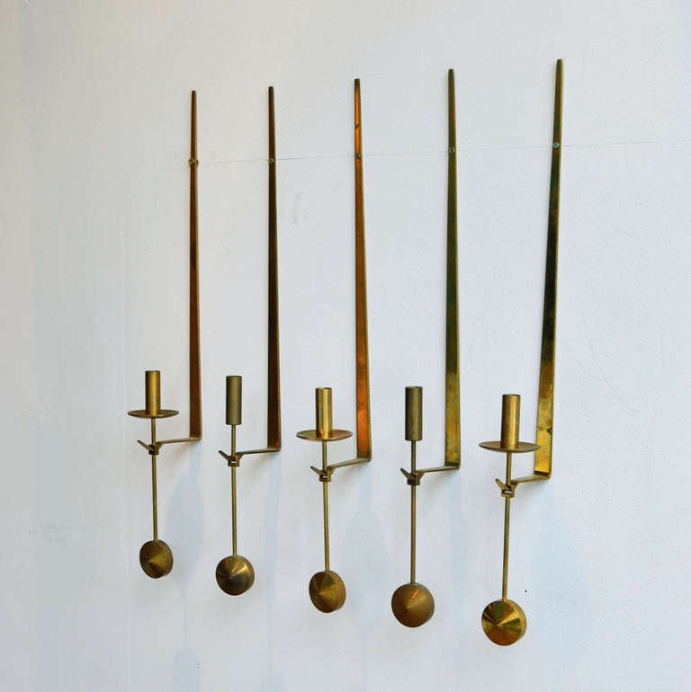A Set of three wall-mounted brass candleholders balancing in an upright position by round brass counter weight.
Beautiful craftsmanship and engineering, manufactured by Skultuna Messingsbruk and designed by Pierre Forsell.
We supply a generous