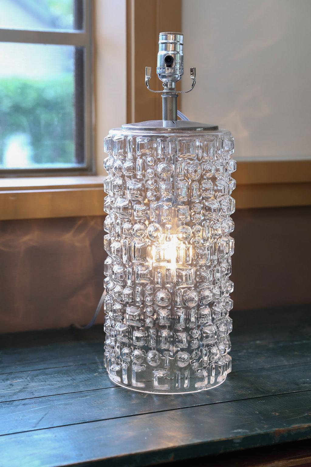 This beautiful Swedish clear glass lamp has been newly wired in the US. Its hardware is nickel-plate over brass.
The height is to the top of the socket. The glass pattern is pleasing and timeless.