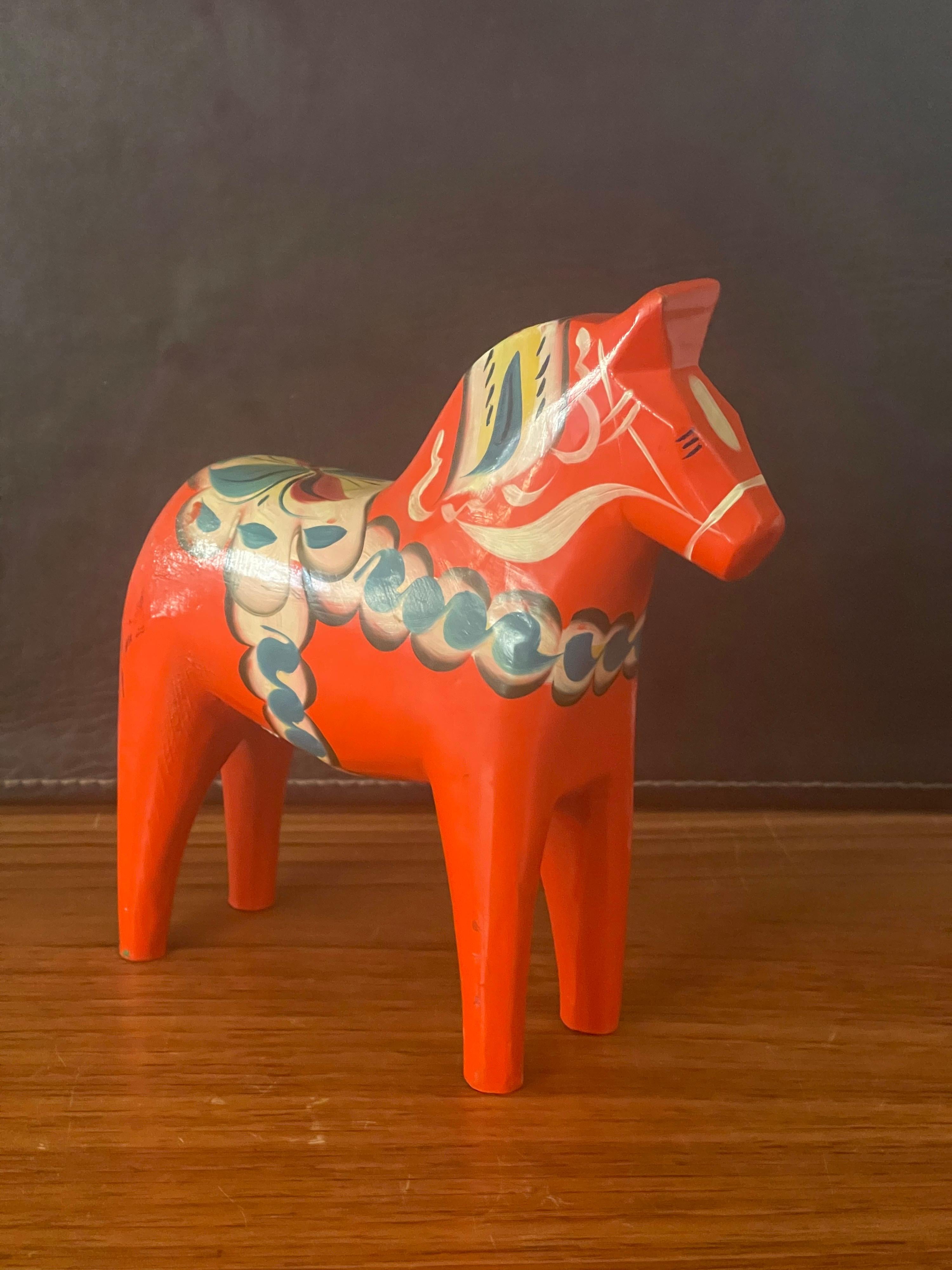 Mid-Century Modern Swedish Dala Horse by Nils Olsson, circa 1960s. The horse is in very good vintage condition and is handpainted orange with festive accents; the piece measures 7.5