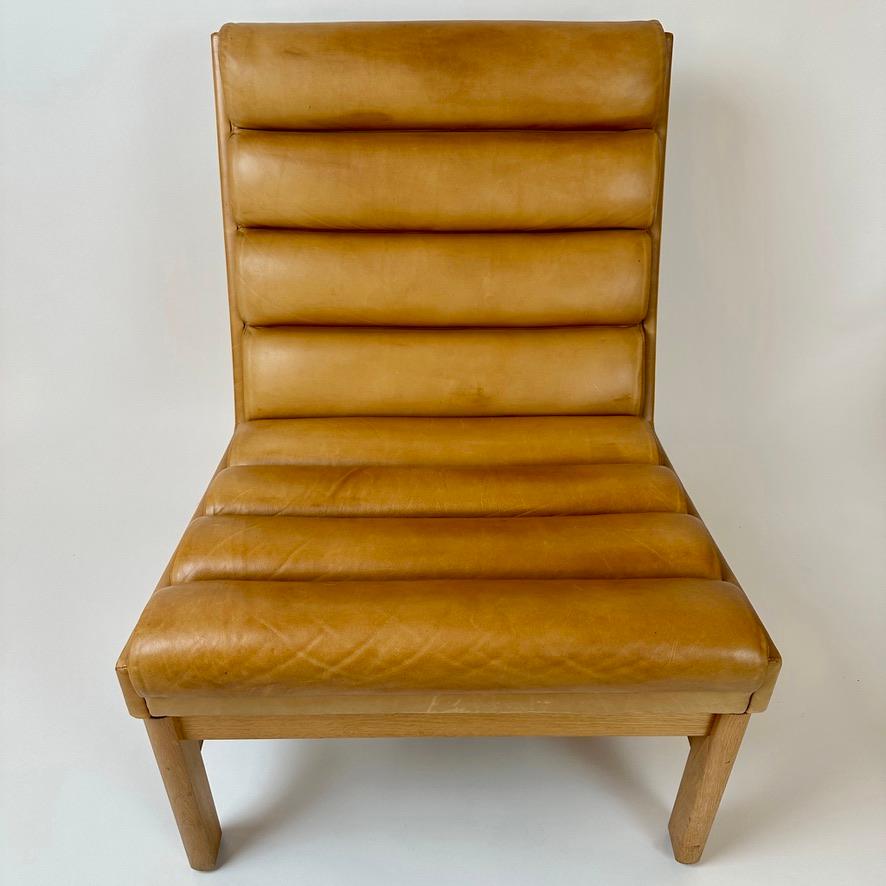 Introducing a rare cognac striped leather lounge chair, manufactured by JOC Vetlanda in 1969. This extremely comfortable lounge chair is a timeless classic, with a high-quality construction that will last for years to come. The frame is made of oak,
