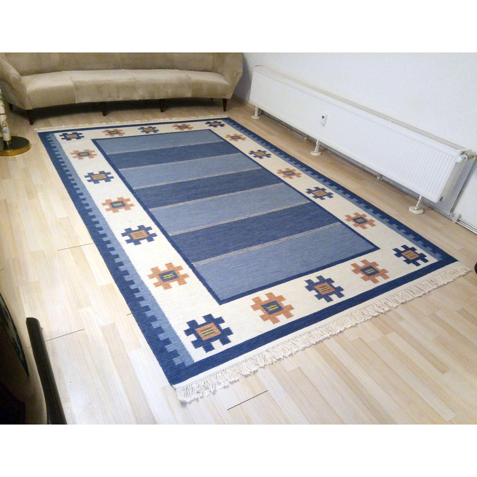 A Mid-Century Modern Swedish Rolakan Kilim, flat-weave Kilim rug, in faded nuances of blue and beige, after a design of Ellen Stahlbrand. This flat-weave carpet features a geometric modern Scandinavian pattern. This midcentury Swedish Rolakan was