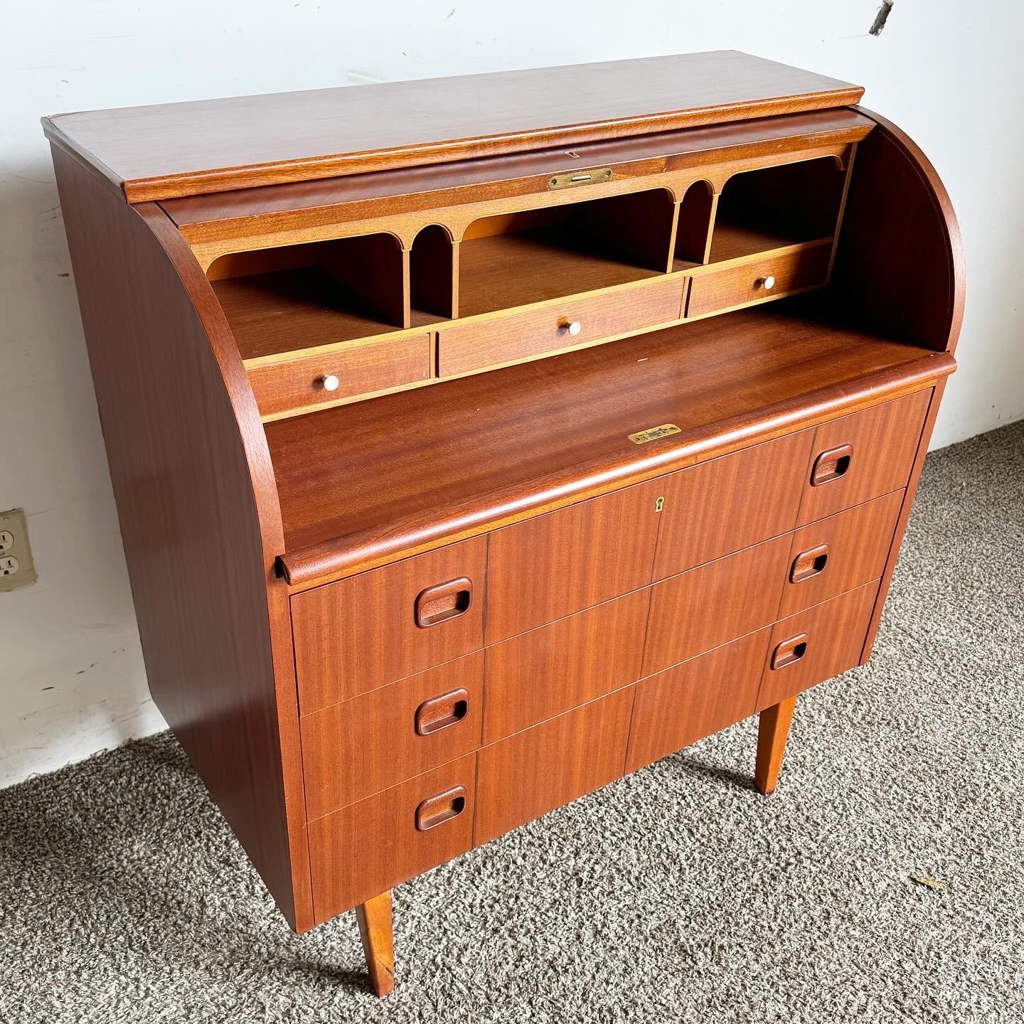 Embrace Scandinavian elegance with the Mid Century Modern Swedish Rolltop Secretary Desk by Egon Ostergaard. This desk, standing at 28.5 inches to the tabletop, features a distinctive rolltop design that extends from 8 to 17 inches, offering