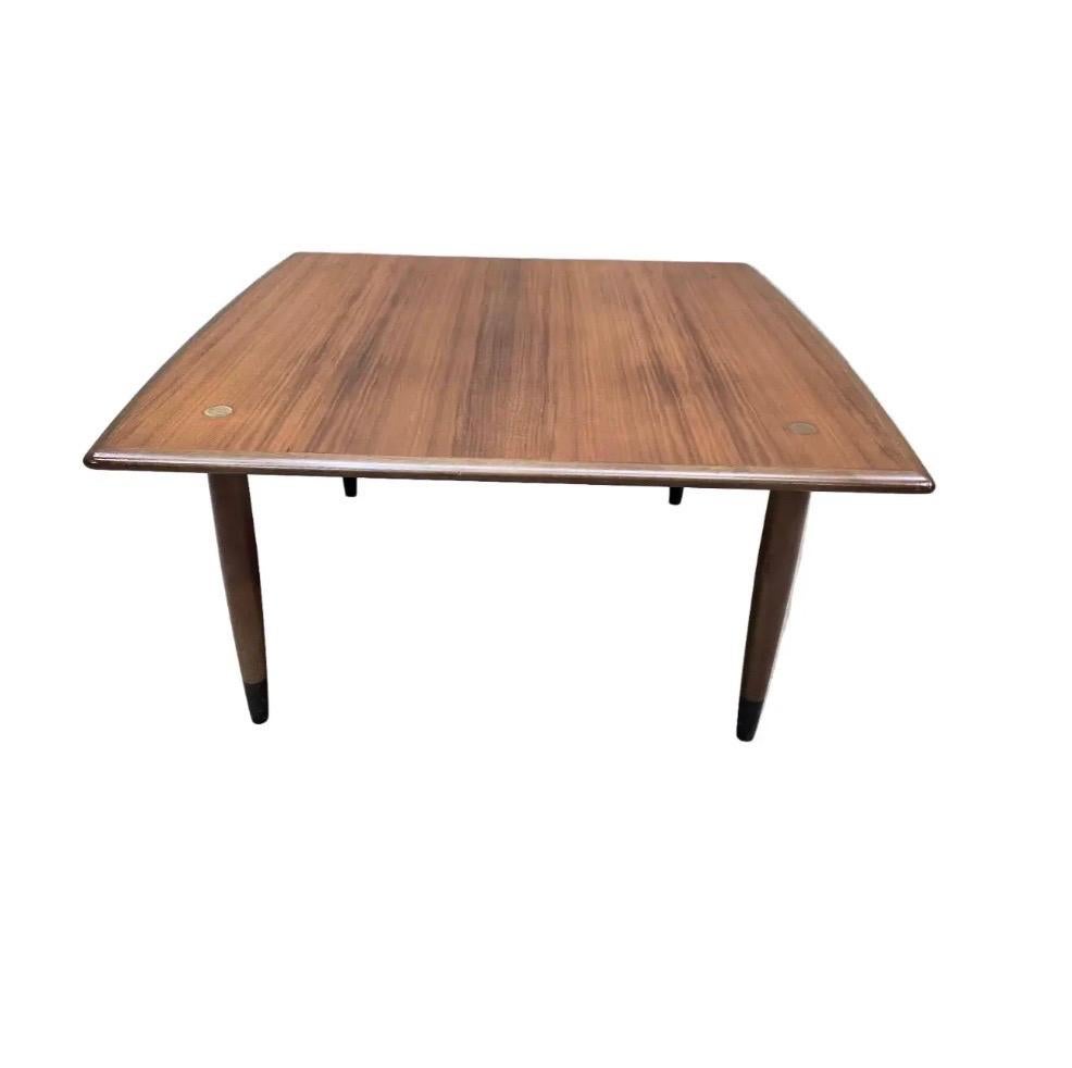 Table basse en teck magnifiquement travaillée par DUX of Sweden, avec des lignes scandinaves chaleureuses et de subtiles incrustations de disques en laiton. Entièrement d'origine et bien conservée, cette pièce capture parfaitement l'attrait