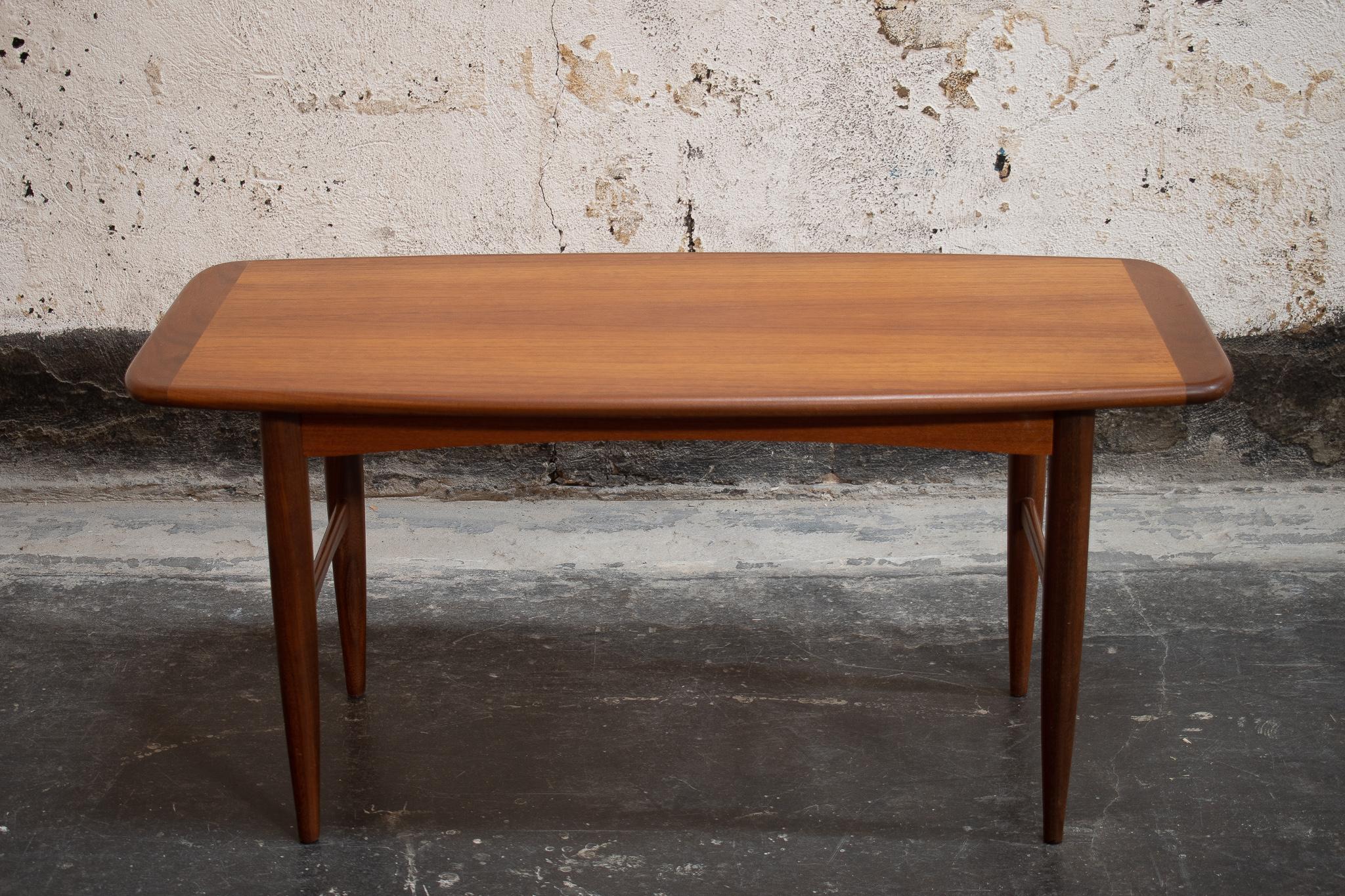 Midcentury Swedish long and slender coffee table, with dark teak border detail. Slightly rounded corners and turned legs complete the perfect mid-mod look. This elegant and understated coffee-table would work well in many design styles including
