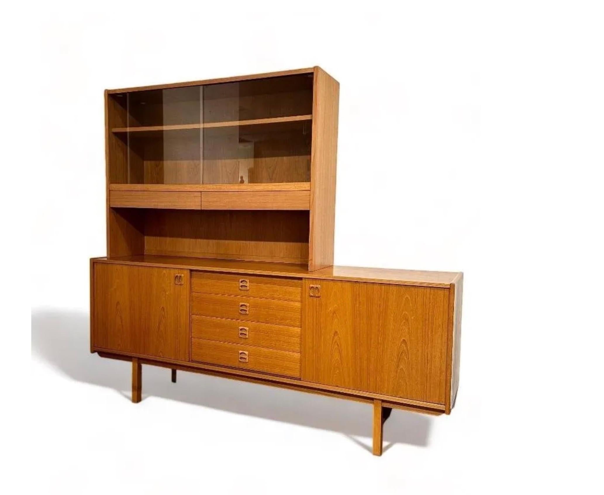 Mid Century Modern Swedish Teak Credenza with 4 drawers and top cabinet unit by Erik Worts. Has a rectangular base with a pair of sliding doors opening to shelves centering four drawers. The credenza is topped by a freestanding Cabinet with two