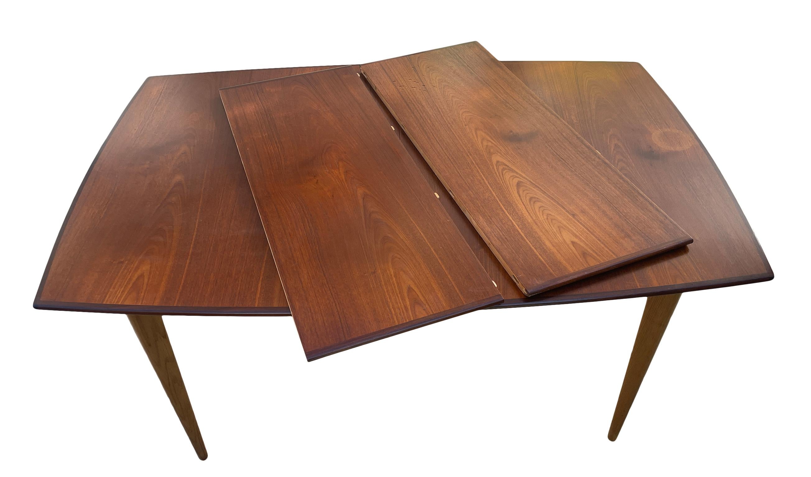 Mid Century Modern Swedish teak Dining table with 2 leaves. Top is made of to teak with rosewood edges and the base and legs are light solid oak. Very unique medium sized dining table. Labeled JOC Mobler Made in Sweden Very Clean Table. Great