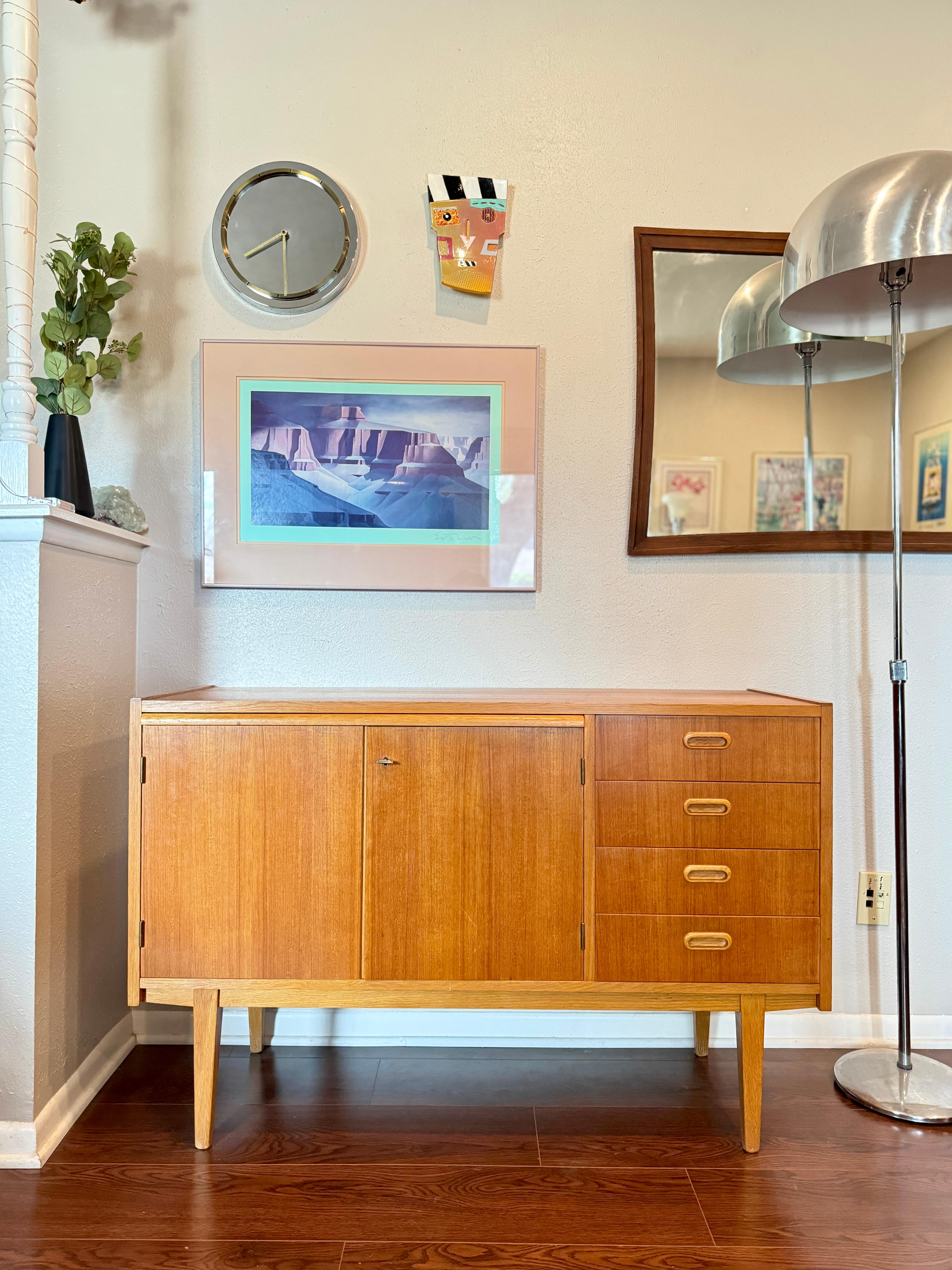 Mid century modern Swedish teak sideboard with pull out desk area, circa 1960s. Includes a sliding desk which can be used as a writing area. The tone of the wood is more of a blonde which I love! Overall in very good original condition, and
