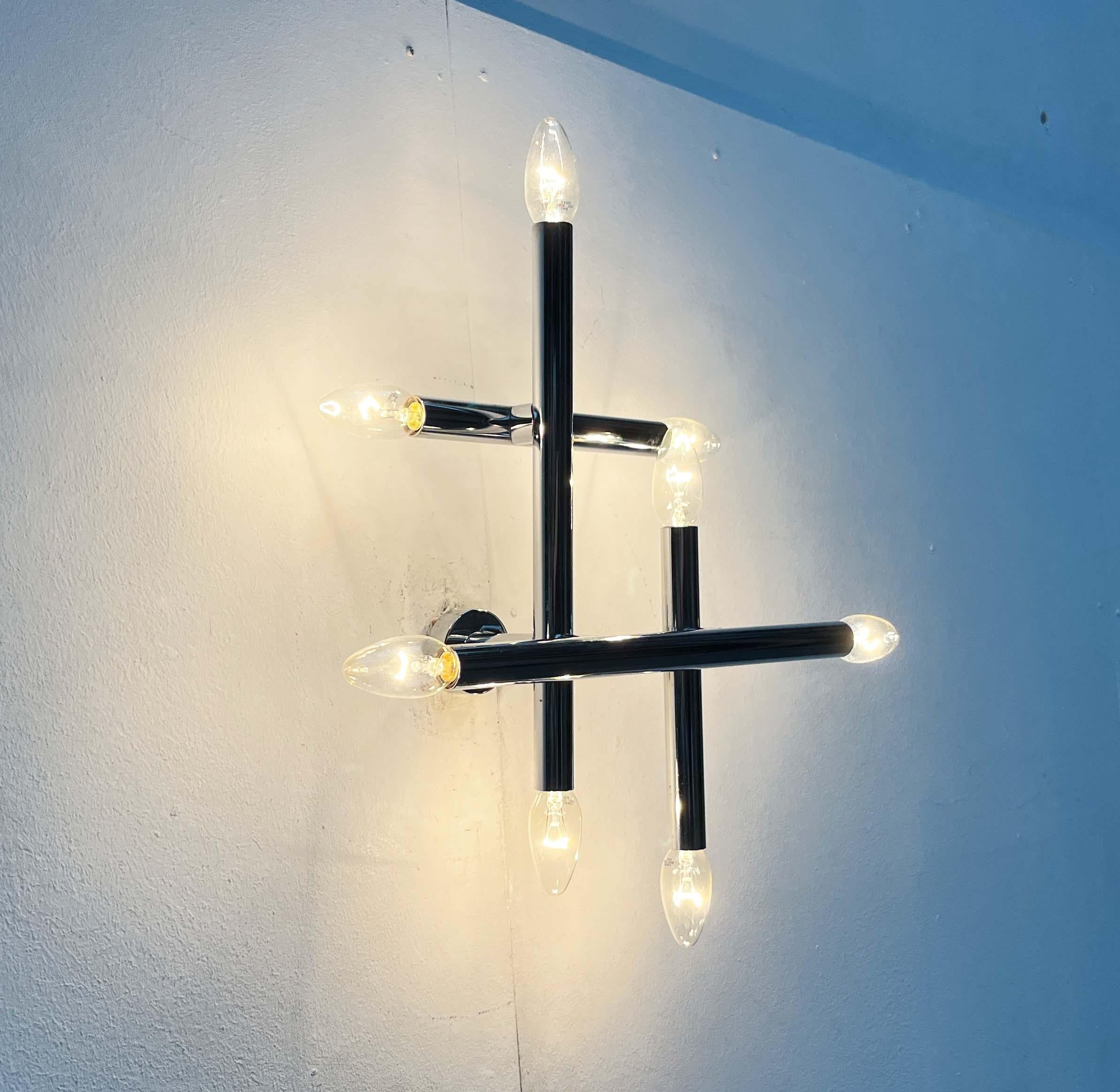 Una lámpara de pared de la era espacial muy rara del renombrado fabricante suizo temde.

una fuente de luz funcional y una compleja escultura luminosa en una habitación. El diseño se basa en la adición de cilindros cromados. Están dispuestas