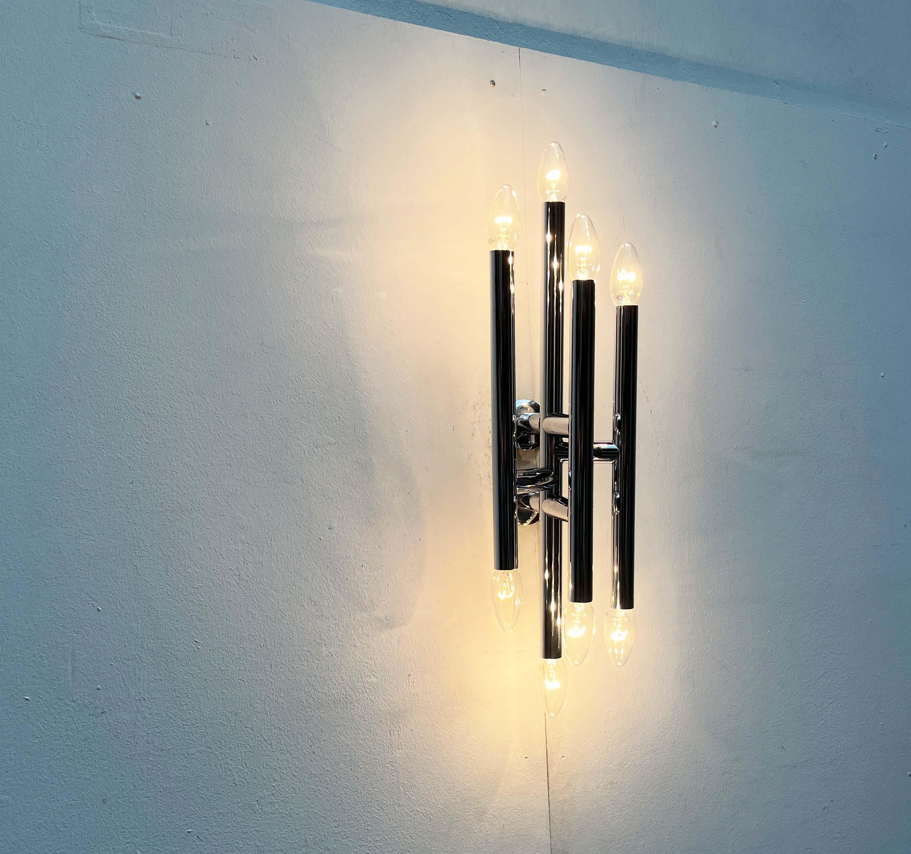 A very rare space age wall lamp from the renowned swiss manufacturer temde.

a functional light source and complex light sculpture in a room. The design is based on the addition of chrome-colored cylinders. These are arranged vertically and