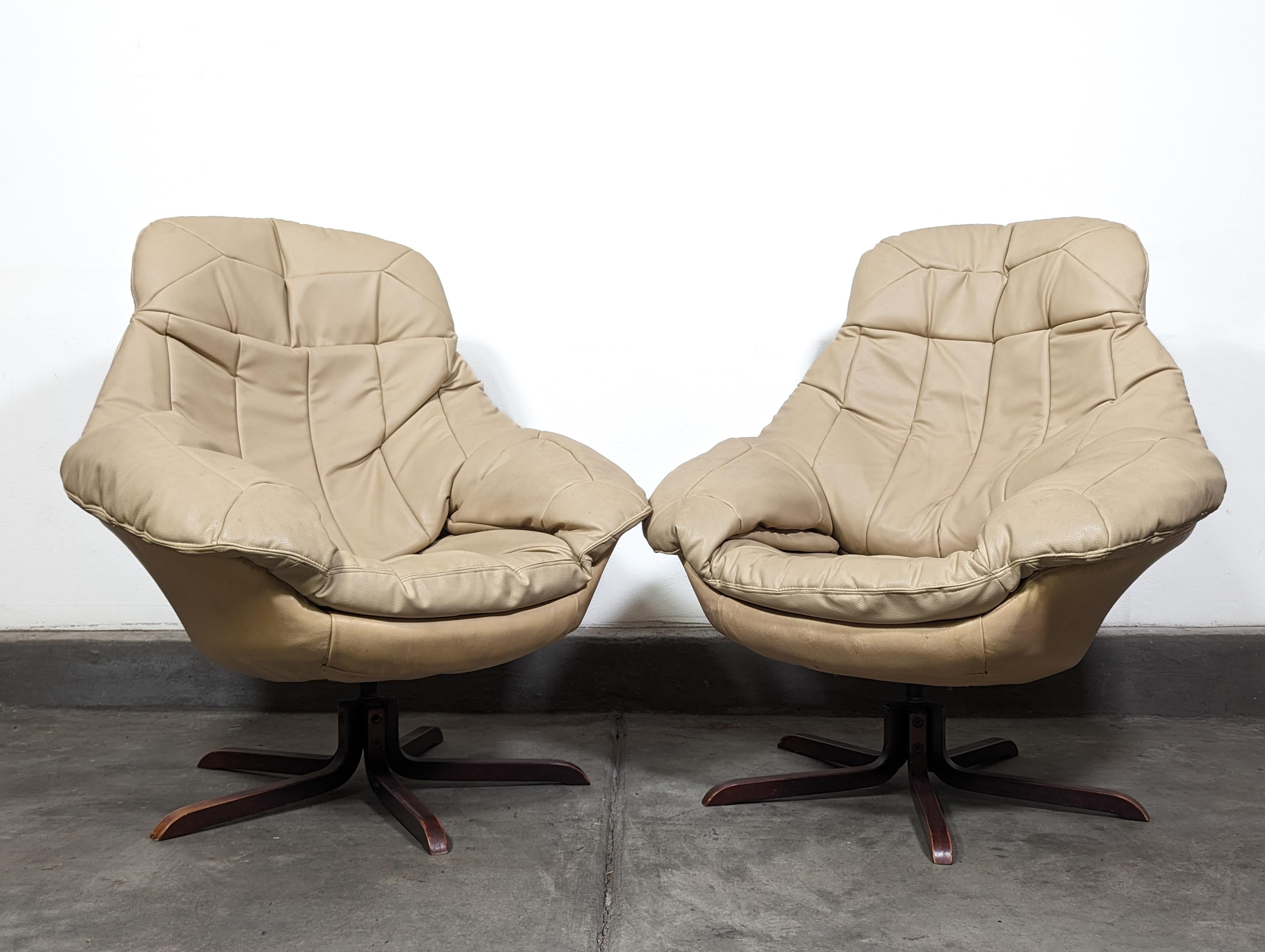 Experience the epitome of mid-century modern elegance and comfort with this exquisite pair of Vintage Swivel Leather Lounge Chairs designed by the renowned H.W. Klein for Bramin, circa 1970s. These chairs are a true testament to the timeless Danish