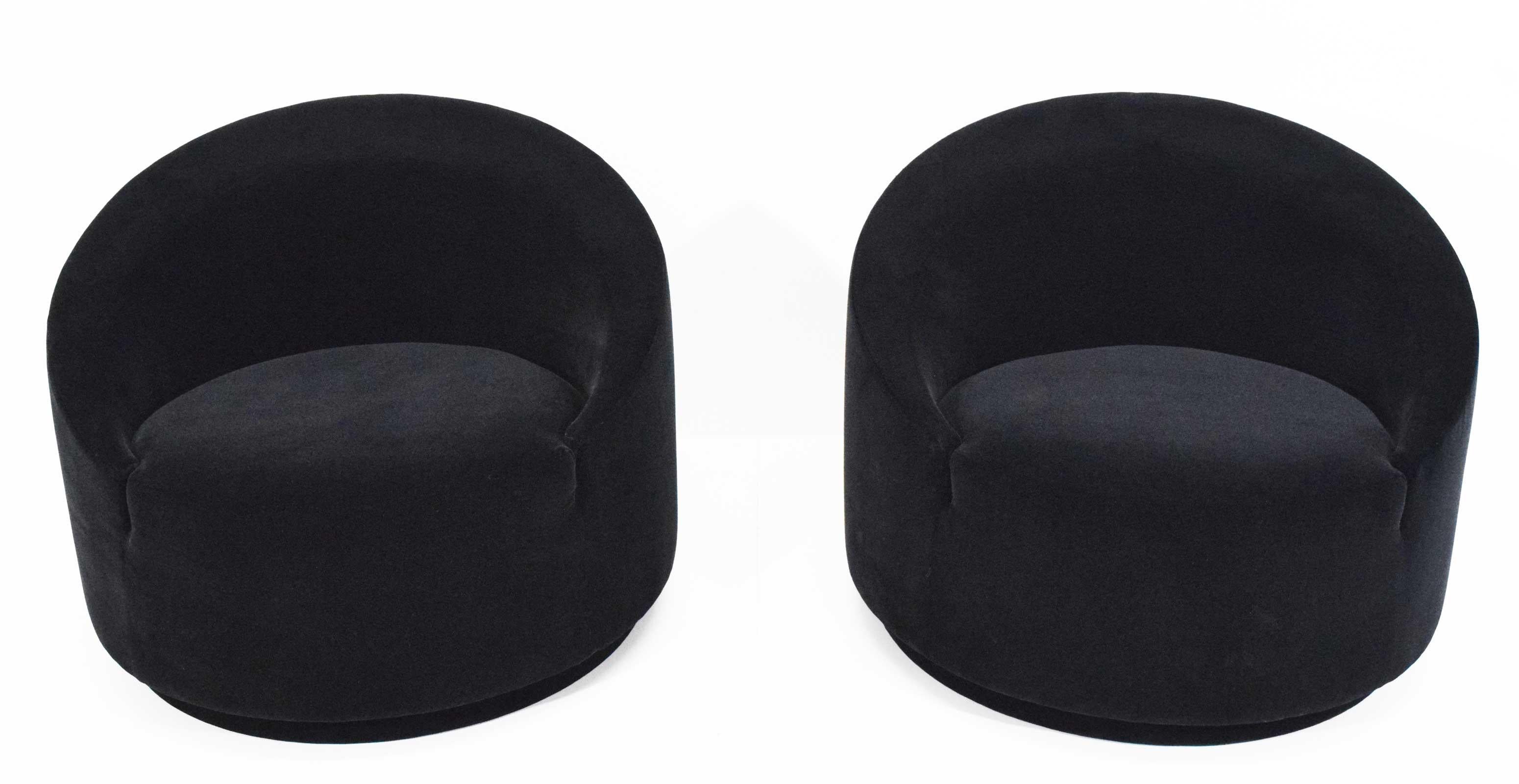 A really very nice pair of cool looking swivel tub chairs upholstered in black mohair by Maharm.