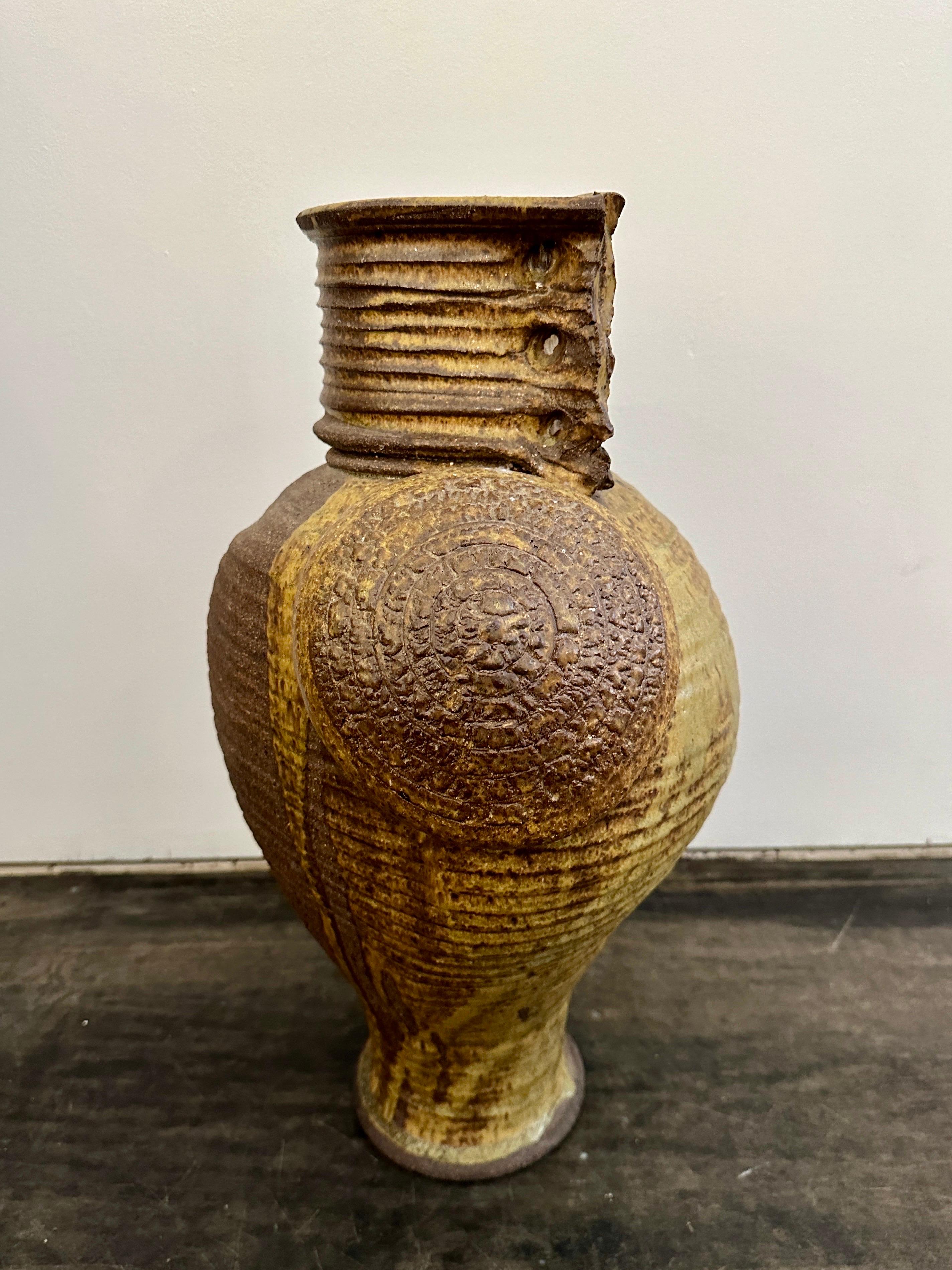 This wonderful oversized ceramic vase from Kaigler 1978 (signed) in rich and subdued earth tones.  Features many details such as a disc element and finger holes for your hand to grip.  This is a heavy and important vase.