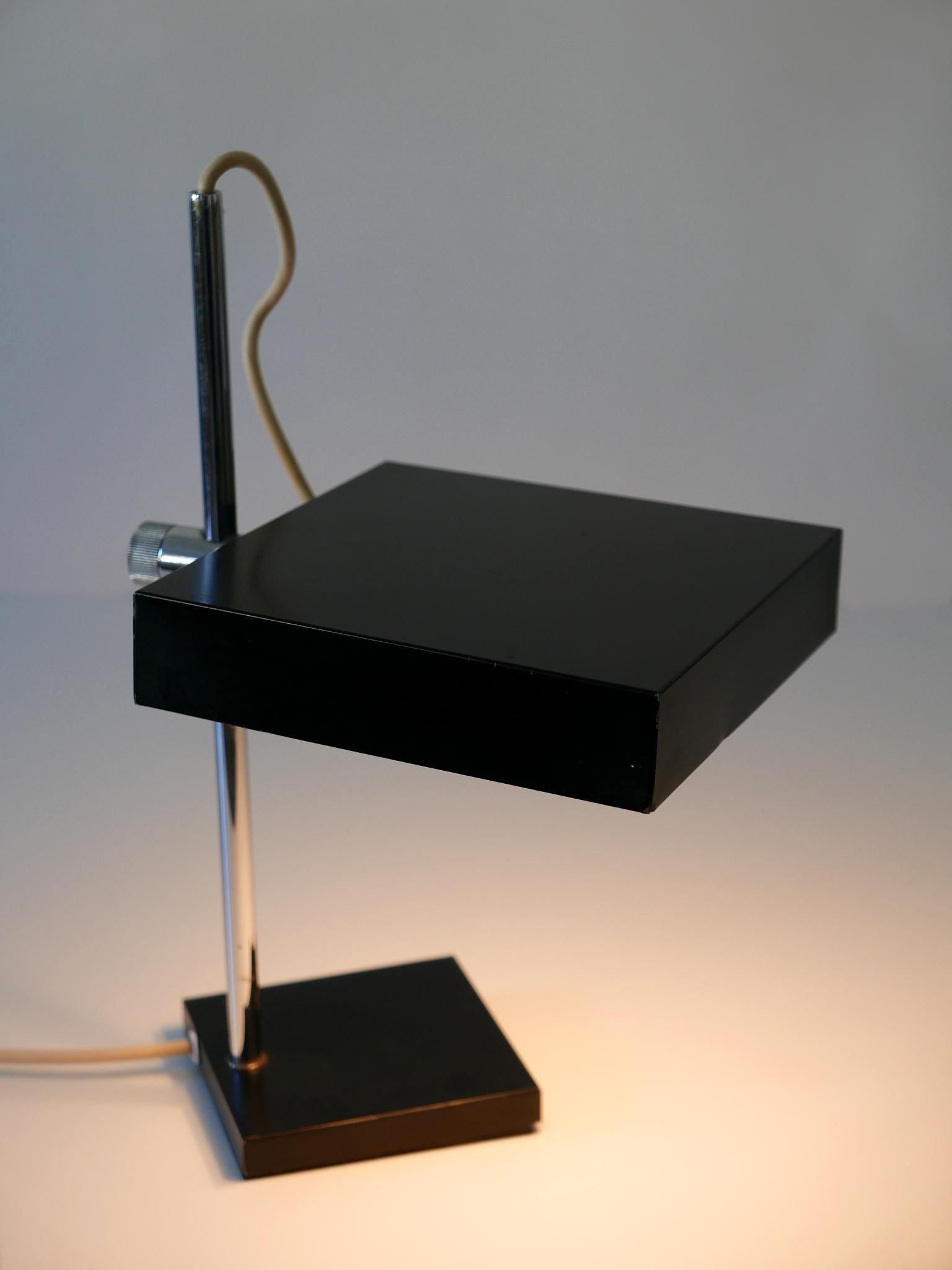 Elegant Mid-Century Modern table lamp or desk light. Modell No 6640. Manufactured by Kaiser Leuchten, 1960s, Germany. Adjustable height and shade.

Executed in black enameled steel, chrome-plated brass tube, the desk light comes with 2 x E14 / E12
