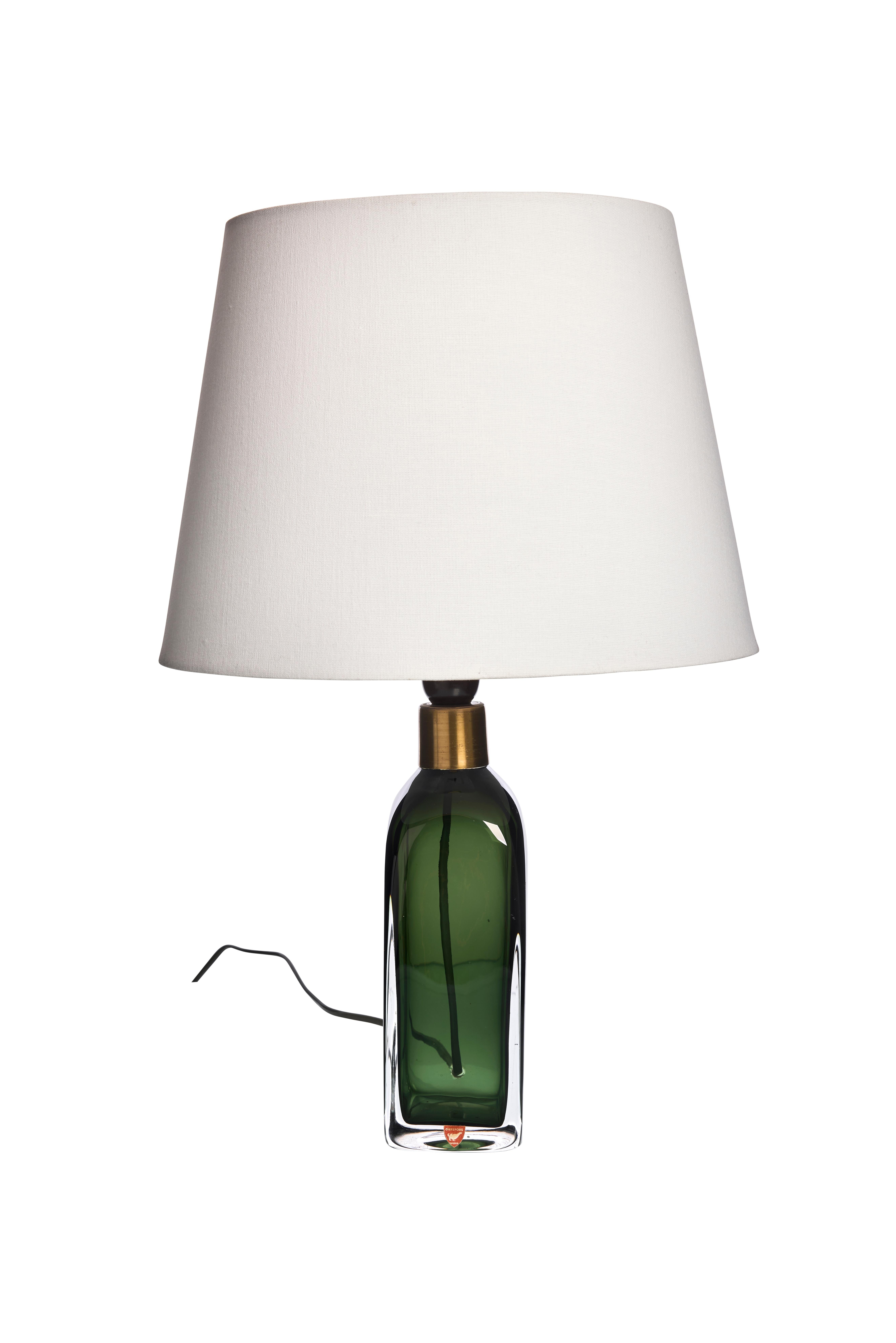 Ajoutez une touche de sophistication intemporelle à votre espace de vie avec cette lampe de table moderne du milieu du siècle, conçue par Carl Fagerlund pour Orrefors. Véritable représentation de l'artisanat scandinave, cette lampe présente une base