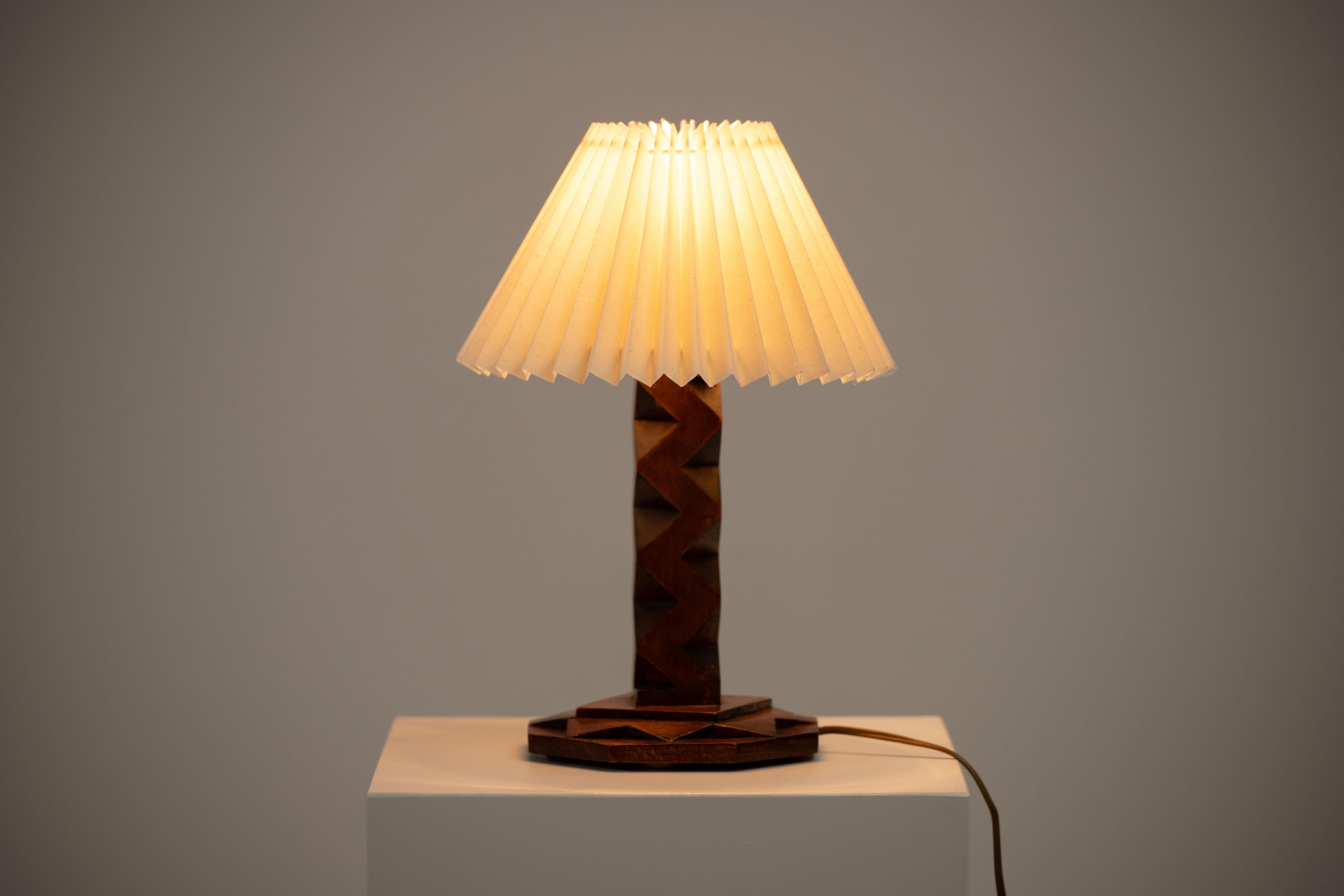 A mid-century table lamp. In solid teak, France, 1940. 

Elegant teak lamps, pleated lampshade. It is in good general condition and works perfectly. The diffused light is very pleasant and the lamp offers a warm atmosphere.

Sold without lampshade,
