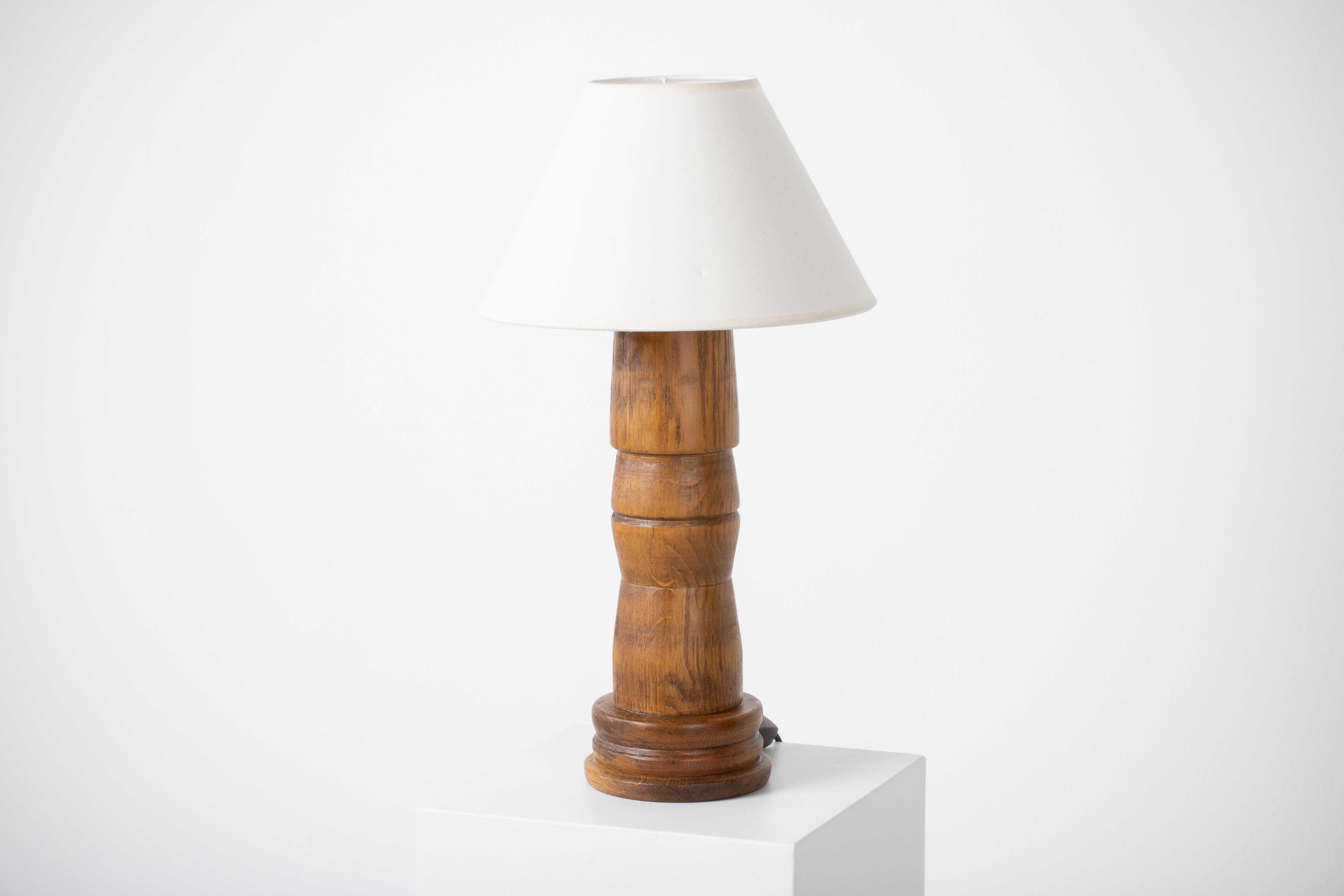 A mid-century table lamp. In solid walnut, France, 1960. 

 It is in good general condition and works perfectly. The diffused light is very pleasant and the lamp offers a warm atmosphere.

Sold without lampshade, height to the socket 34 cm.