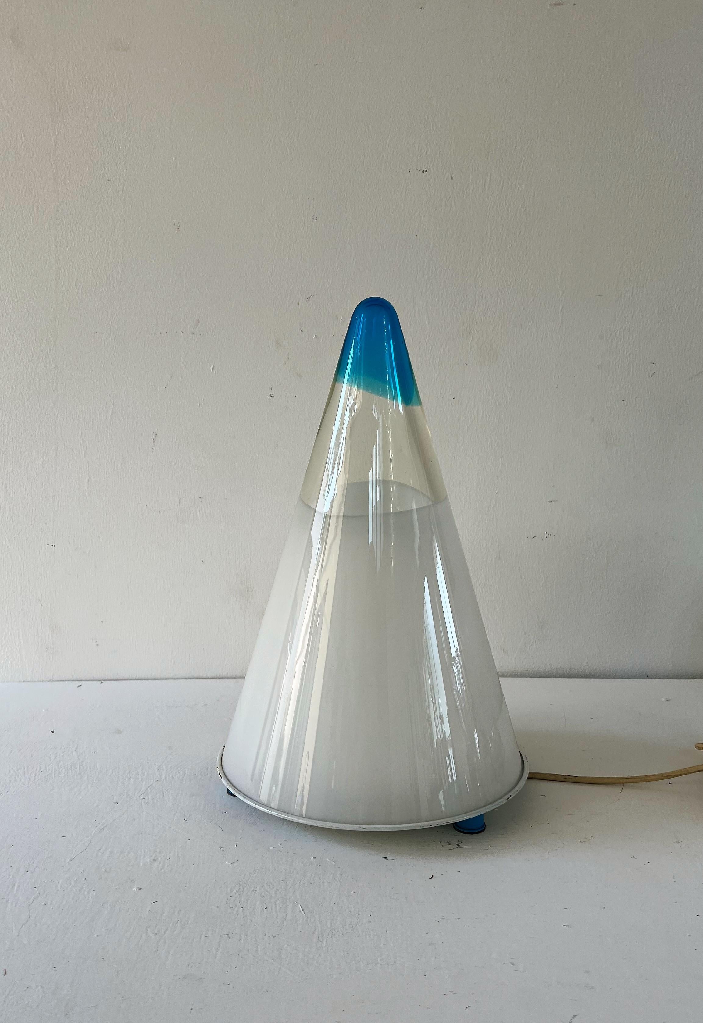 Beautiful lamp from the Space Age era in the shape of a cone.
The Murano glass shade is manufactured in white, blue and clear.
The metal base is lacquered in white and blue.
Lamp holds one e27 bulb.