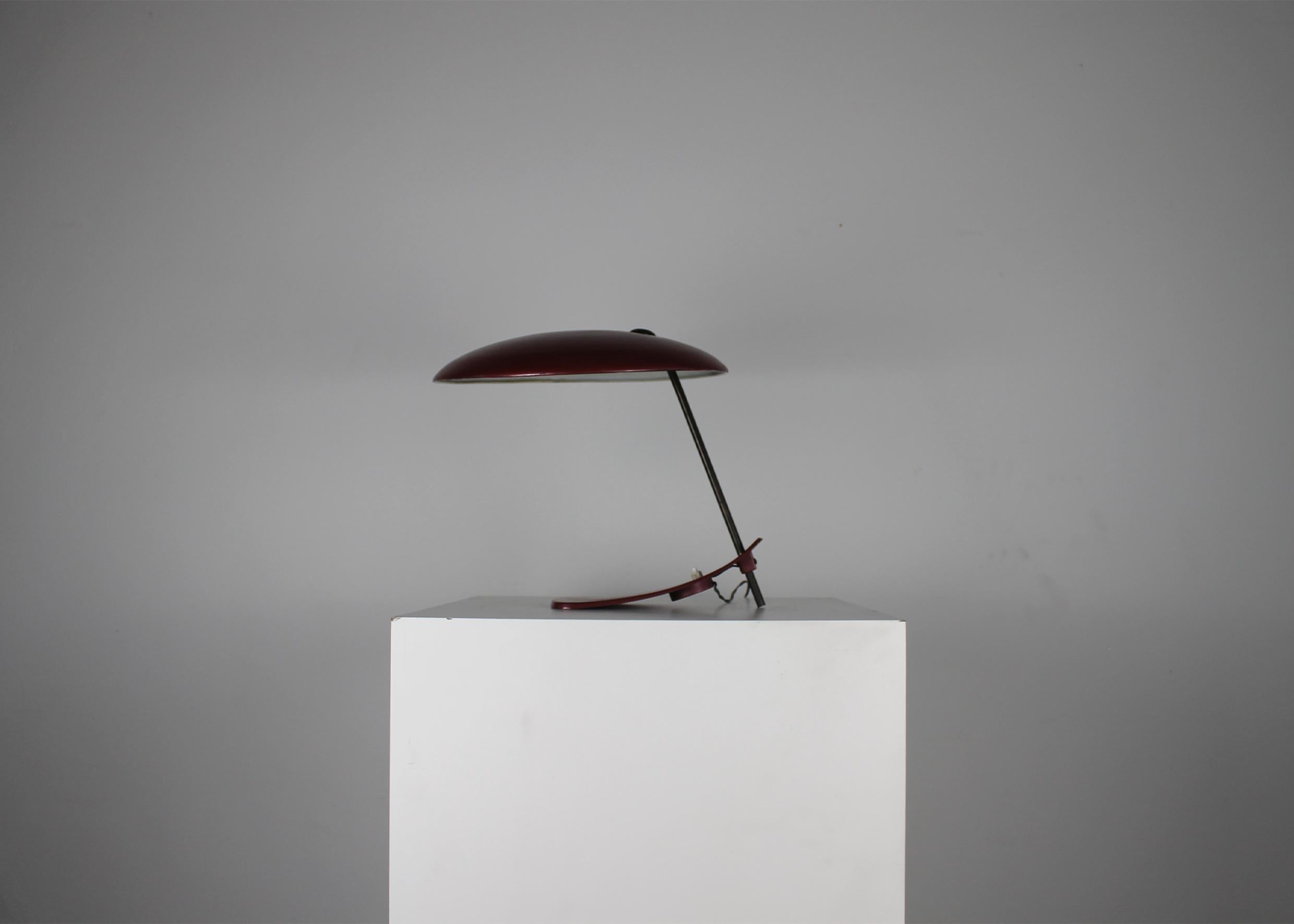 A rare Mid-Century Modern table or desk lamp with a stem in metal, a base, and a lampshade in red lacquered metal. 

Manufactured in Italy during the 1950s. 







.